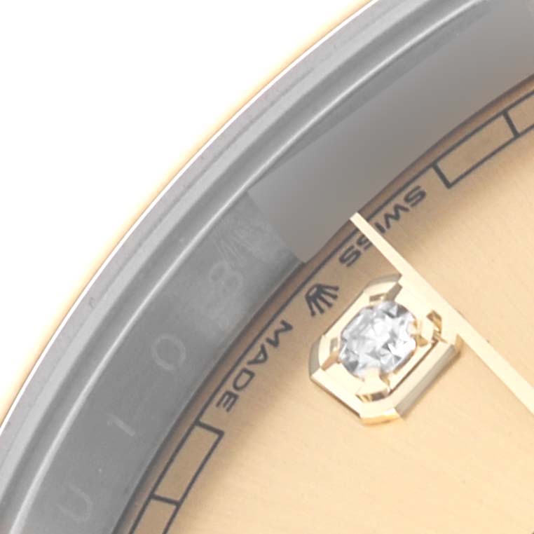 The image shows a close-up of the bezel and part of the dial of a Rolex Datejust 41 126303 Men
s Steel and Gold (two tone) Champagne Dial 126303 Men
s Steel and Gold (two tone) Champagne Dial, highlighting details like the diamond index.