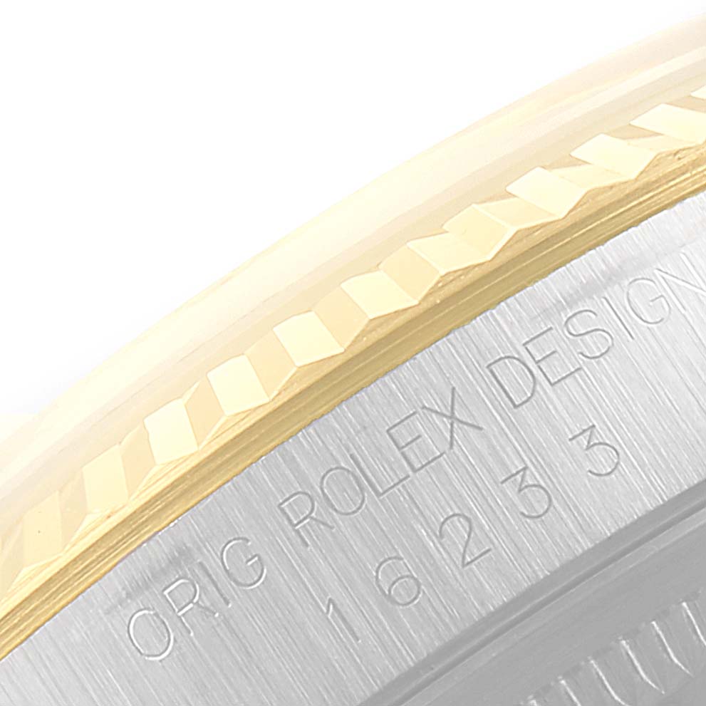 The image shows a partial side view of the fluted bezel and case of a Rolex Datejust 16233 Men
s Steel and Gold (two tone) Champagne Dial 16233 Men
s Steel and Gold (two tone) Champagne Dial watch, highlighting the serial number engraving.