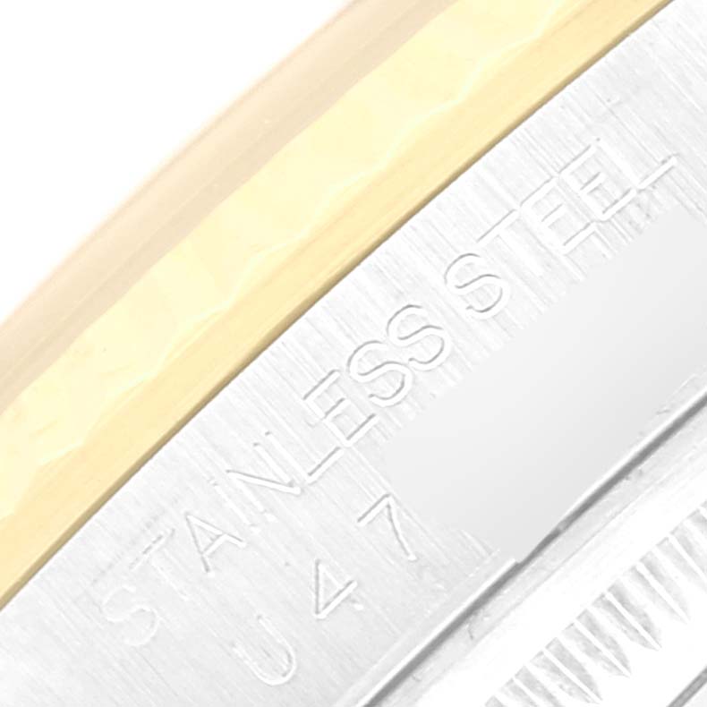Close-up of the Rolex Datejust 16233 Men's Steel and Gold (two tone) Silver Dial 16233 Men's Steel and Gold (two tone) Silver Dial's side, showing part of the bracelet and engraved text on the stainless steel casing.