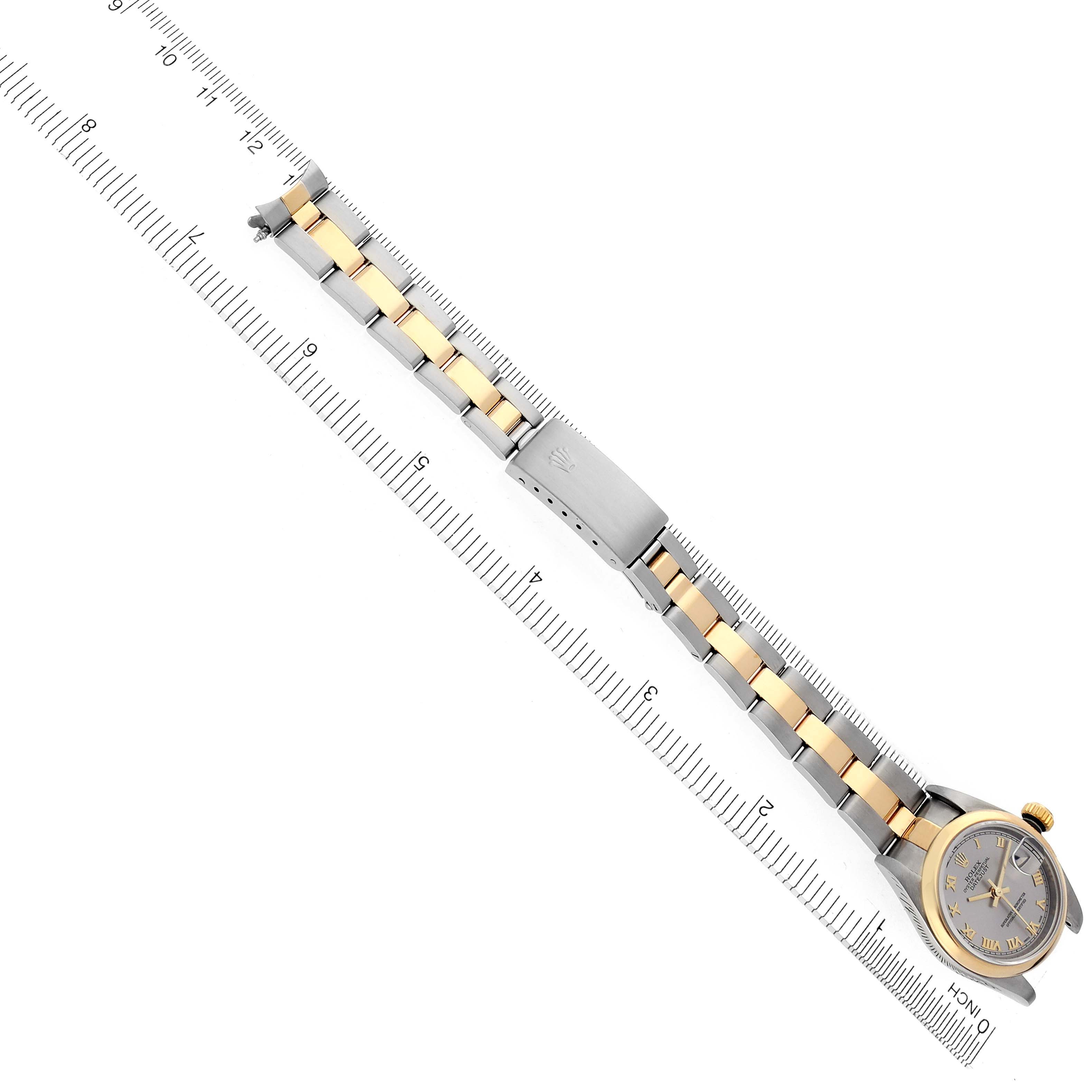 The Rolex Datejust 79163 Women's Steel and Gold (two tone) Grey Dial 79163 Women's Steel and Gold (two tone) Grey Dial watch is shown from a top angle, displaying the face and full bracelet, alongside a measuring ruler.