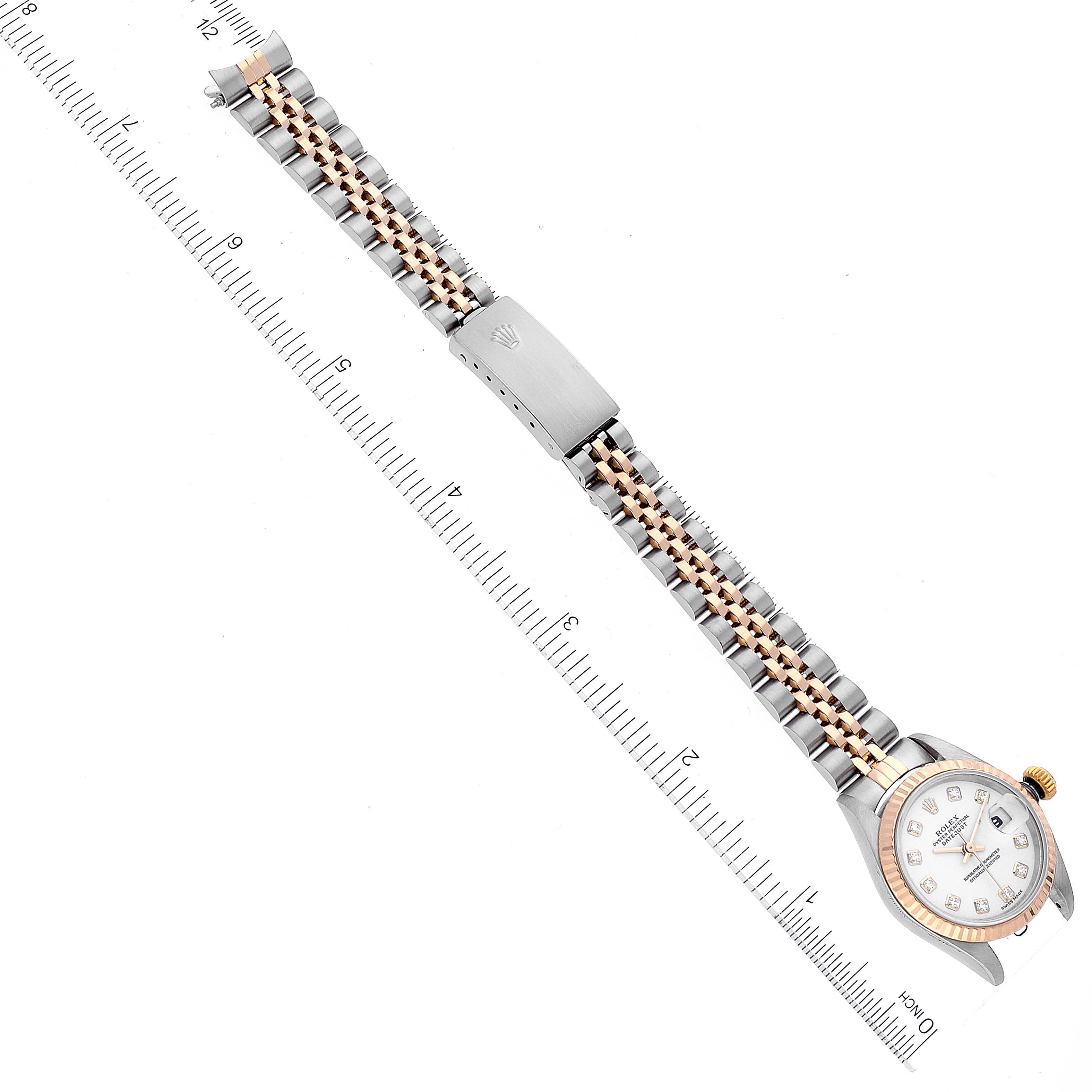 The image shows a Rolex Datejust 79173 Women's Steel and Gold (two tone) White Dial 79173 Women's Steel and Gold (two tone) White Dial watch laid flat, showcasing the strap, clasp, and face, with a ruler for scale.