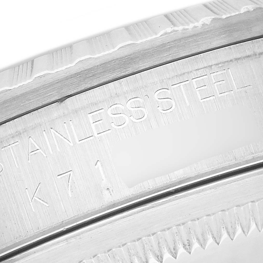 The image shows a close-up of the engravings on the stainless steel side of the bezel of a Rolex Datejust 16220 Men's Stainless Steel White Dial 16220 Men's Stainless Steel White Dial watch.
