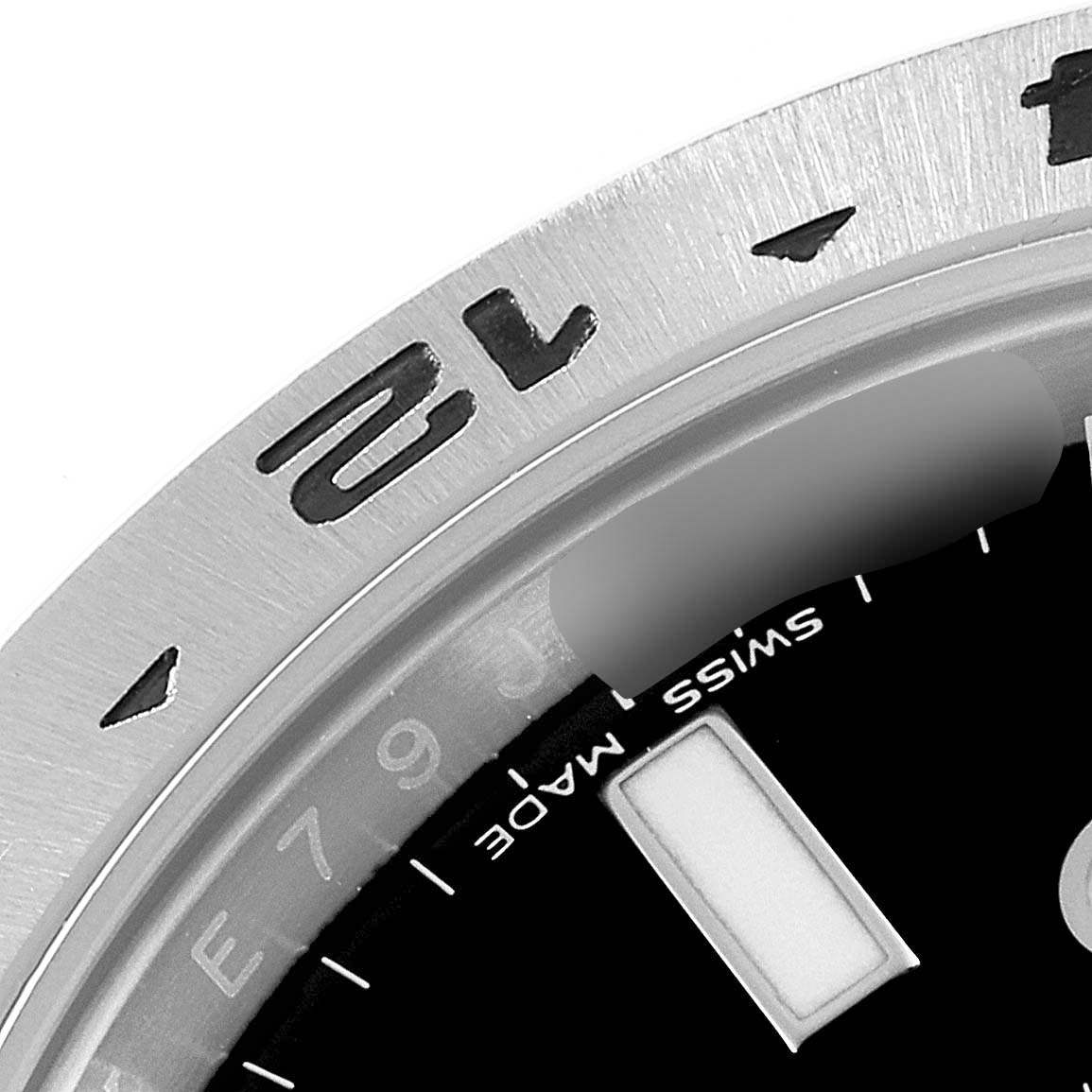 The image shows a close-up of the bezel and partial dial of a Rolex Explorer 216570 Men's Stainless Steel Black Dial 216570 Men's Stainless Steel Black Dial watch, highlighting the 12 o'clock marker and "Swiss Made" text.