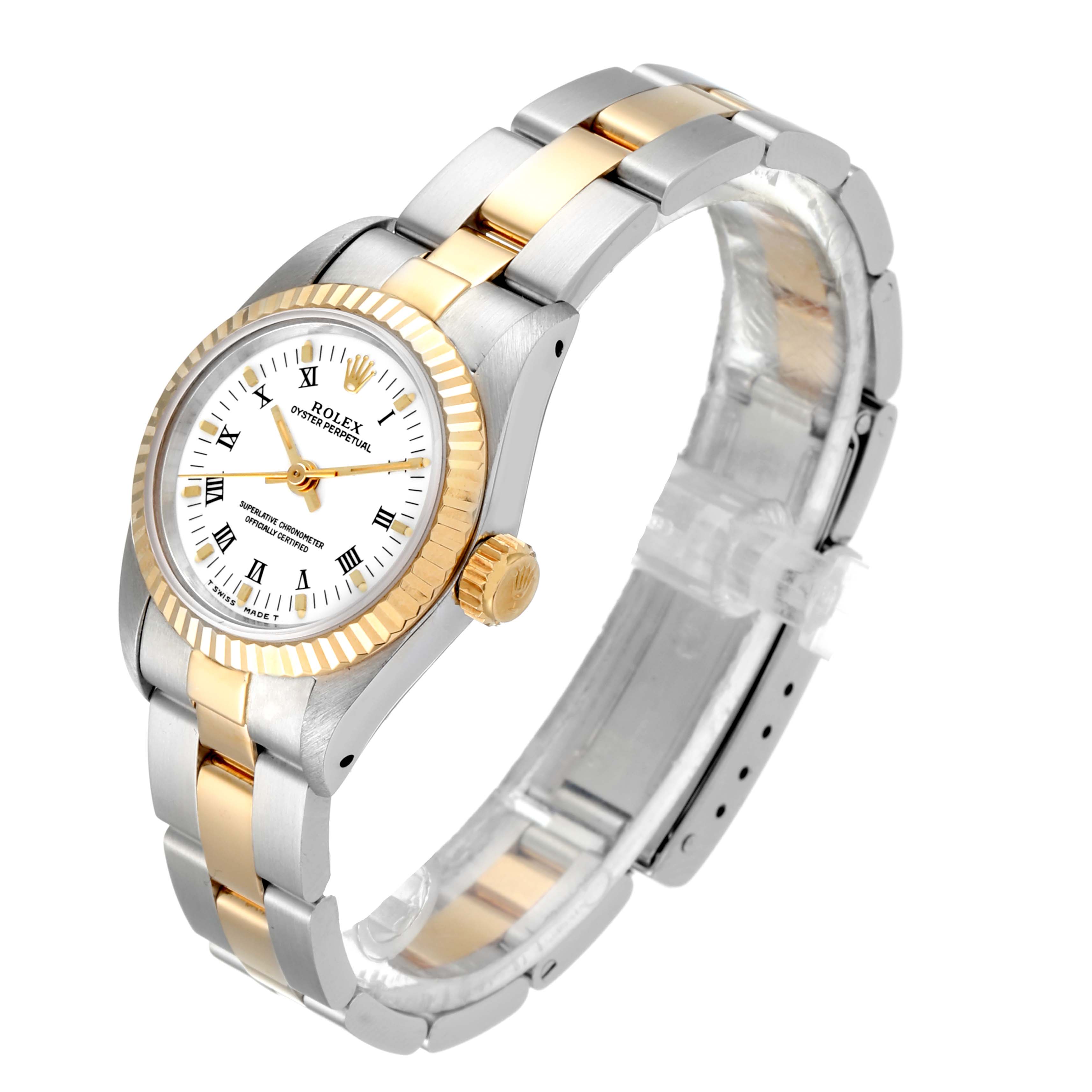 The Rolex Oyster Perpetual 67193 Women's Steel and Gold (two tone) White Dial 67193 Women's Steel and Gold (two tone) White Dial watch is shown from a front-left angle, highlighting its two-tone bracelet and bezel, and its dial with Roman numerals.