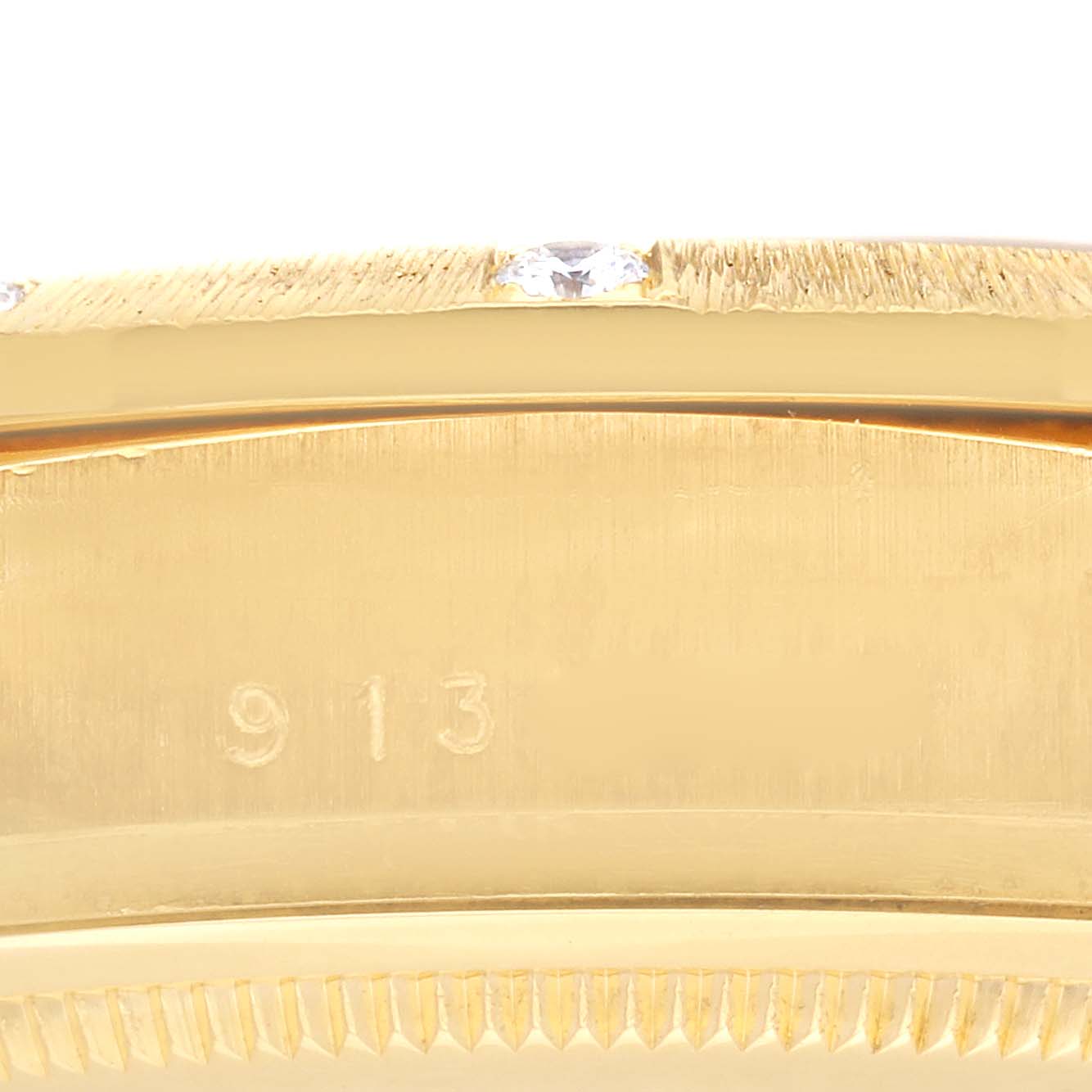 The image shows a close-up of the bezel and side of a Rolex President 18108 Men
s Yellow Gold Champagne Dial 18108 Men
s Yellow Gold Champagne Dial model watch, highlighting its gold finish and small numeral detail.