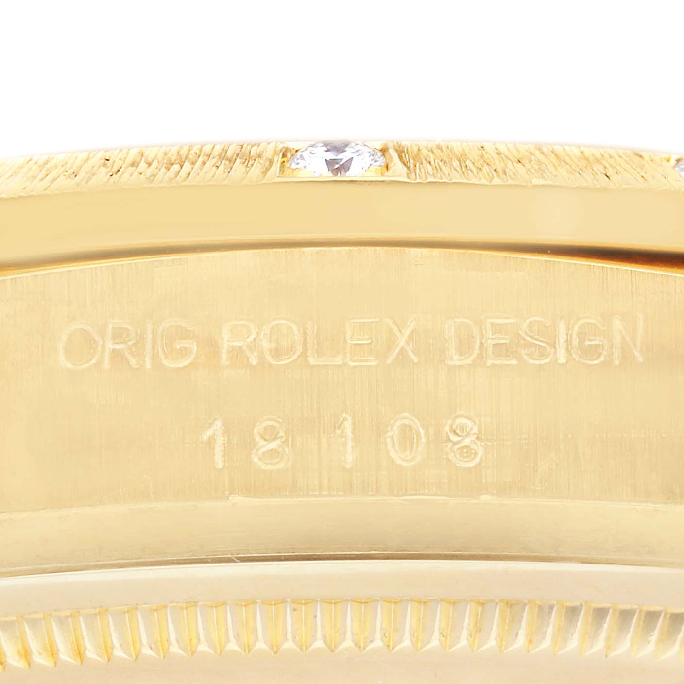The image shows a close-up of the case side of a Rolex President 18108 Men
s Yellow Gold Champagne Dial 18108 Men
s Yellow Gold Champagne Dial model, highlighting the "Orig Rolex Design" engraving and a diamond detail.