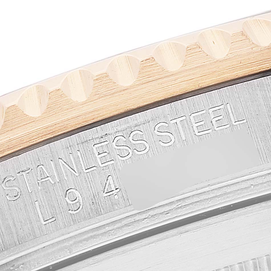 This image shows a close-up of the engraved text and bezel edge of a Rolex Submariner 16613 Men's Steel and Gold (two tone) Blue Dial 16613 Men's Steel and Gold (two tone) Blue Dial watch.