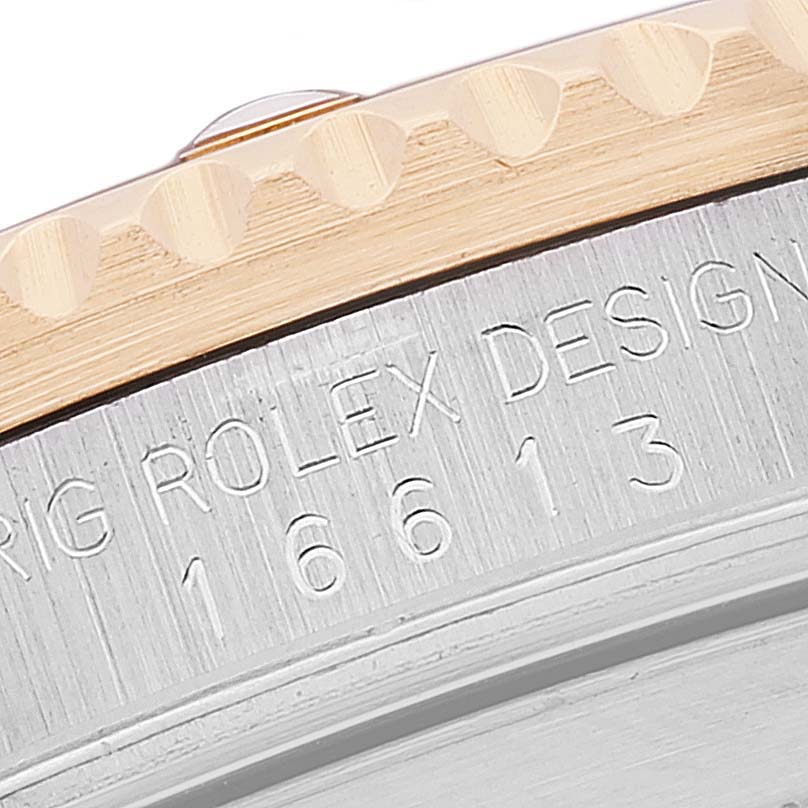 The image shows a close-up of the engraved bezel and case side of a Rolex Submariner 16613 Men's Steel and Gold (two tone) Blue Dial 16613 Men's Steel and Gold (two tone) Blue Dial.