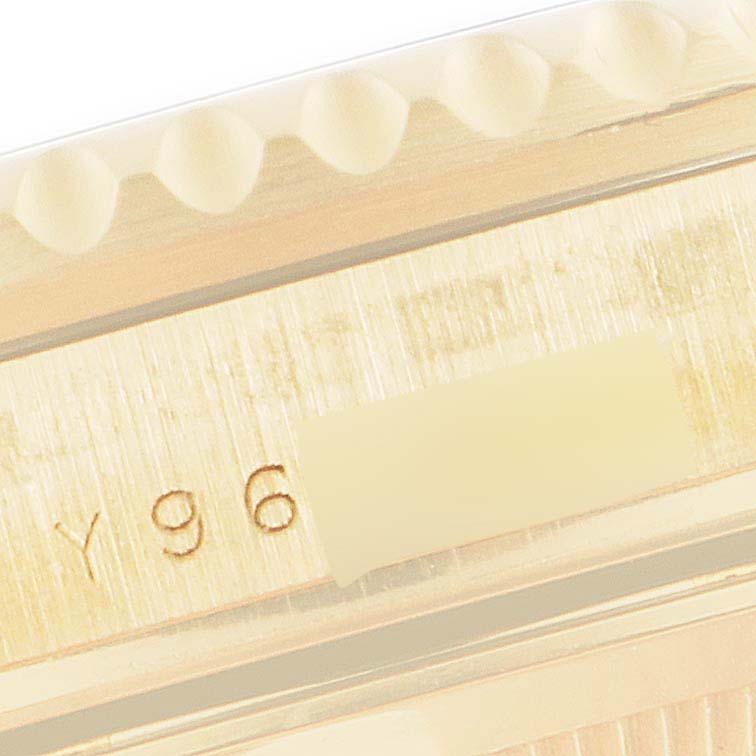 This close-up image shows part of the case and bezel of a Rolex Submariner 16618 Men
s Yellow Gold Blue Dial 16618 Men
s Yellow Gold Blue Dial watch, including some serial number engraving.