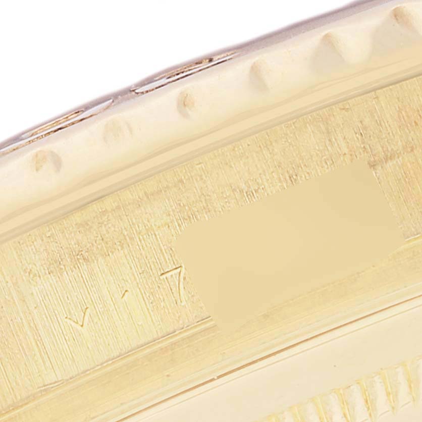 This image shows a close-up of the side view of a Rolex Yacht-Master 16628 Men's Yellow Gold White Dial 16628 Men's Yellow Gold White Dial watch bezel, highlighting its edge and etched serial number.