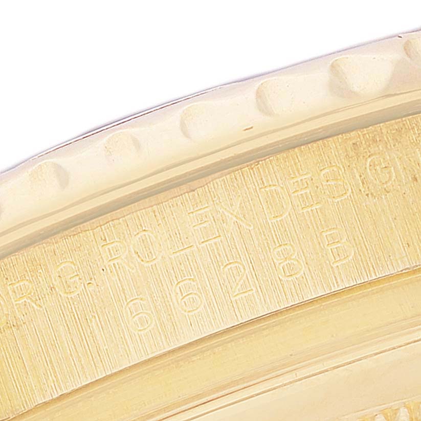 This close-up image shows the engraved bezel edge of a Rolex Yacht-Master 16628 Men's Yellow Gold White Dial 16628 Men's Yellow Gold White Dial watch.