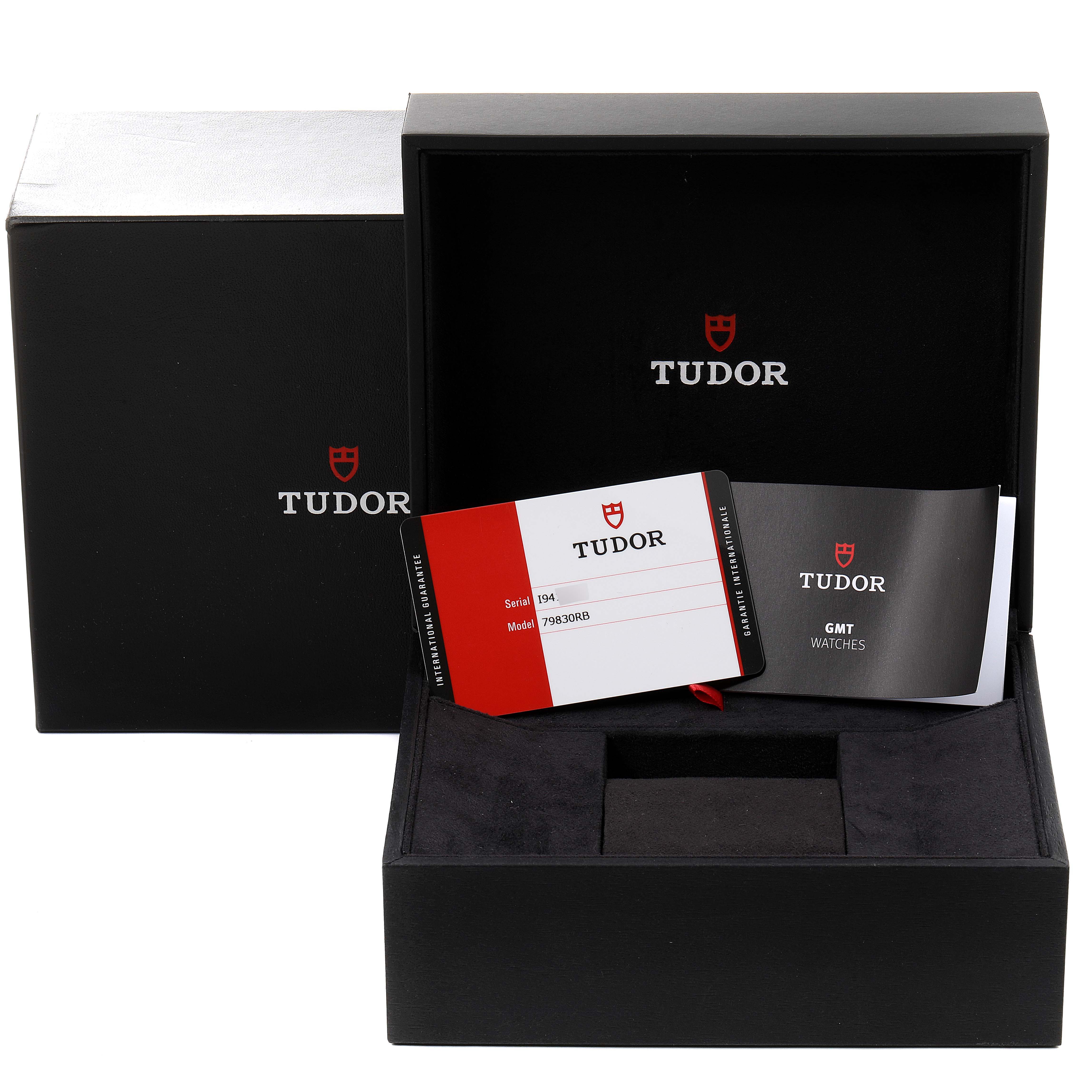 The image shows the Tudor Heritage Black Bay 79830RB Men's Stainless Steel Black Dial 79830RB Men's Stainless Steel Black Dial watch's open box, warranty card, and booklet from a front angle.