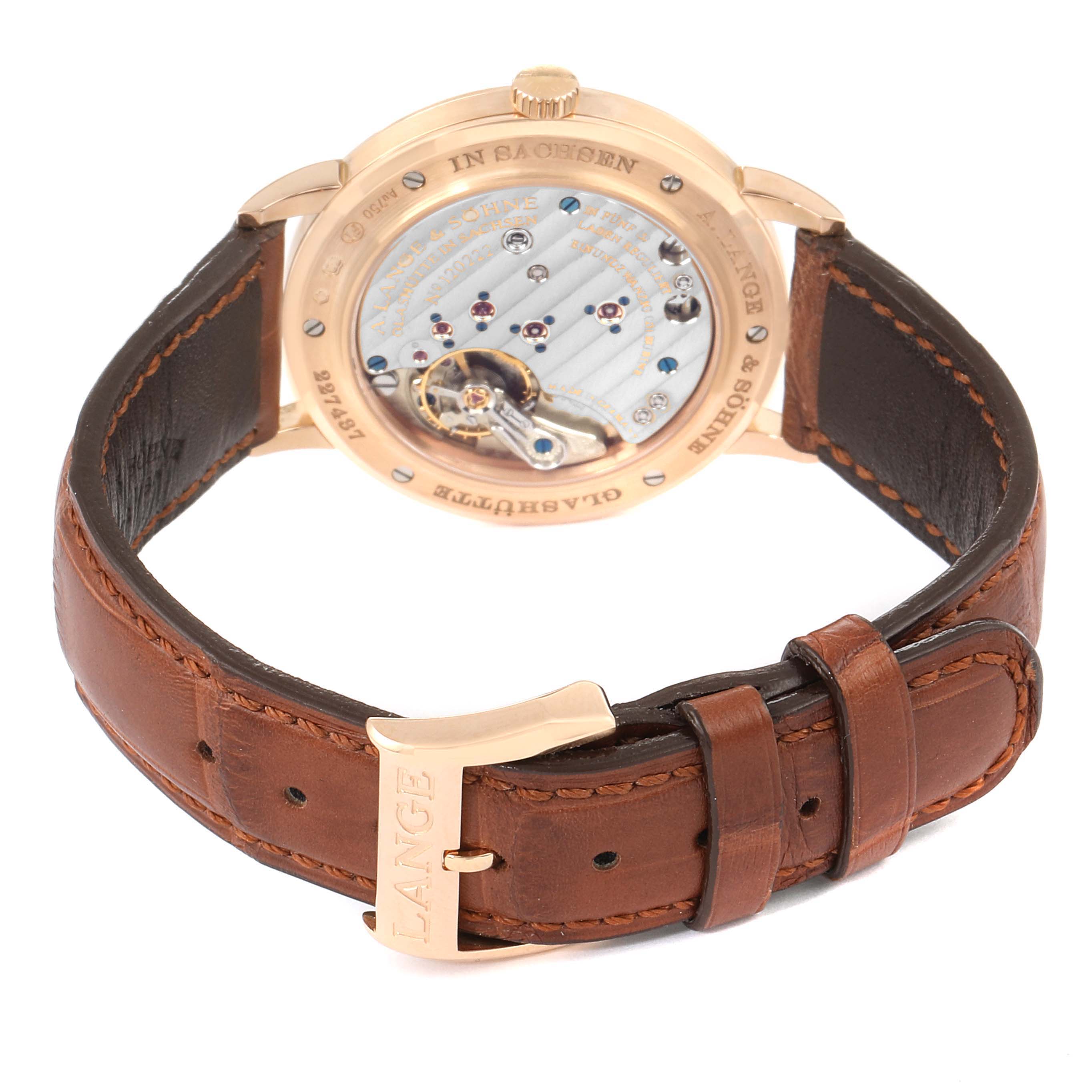 The image displays the back view of an A. Lange & Sohne Saxonia 219.032 Men's Rose Gold Silver Dial watch, highlighting its movement and brown leather strap.