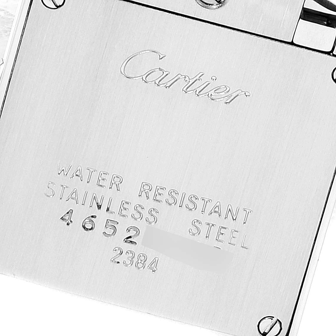 The image shows the back plate of a Cartier Tank Française watch at a close-up angle, displaying "Cartier" and specifications.