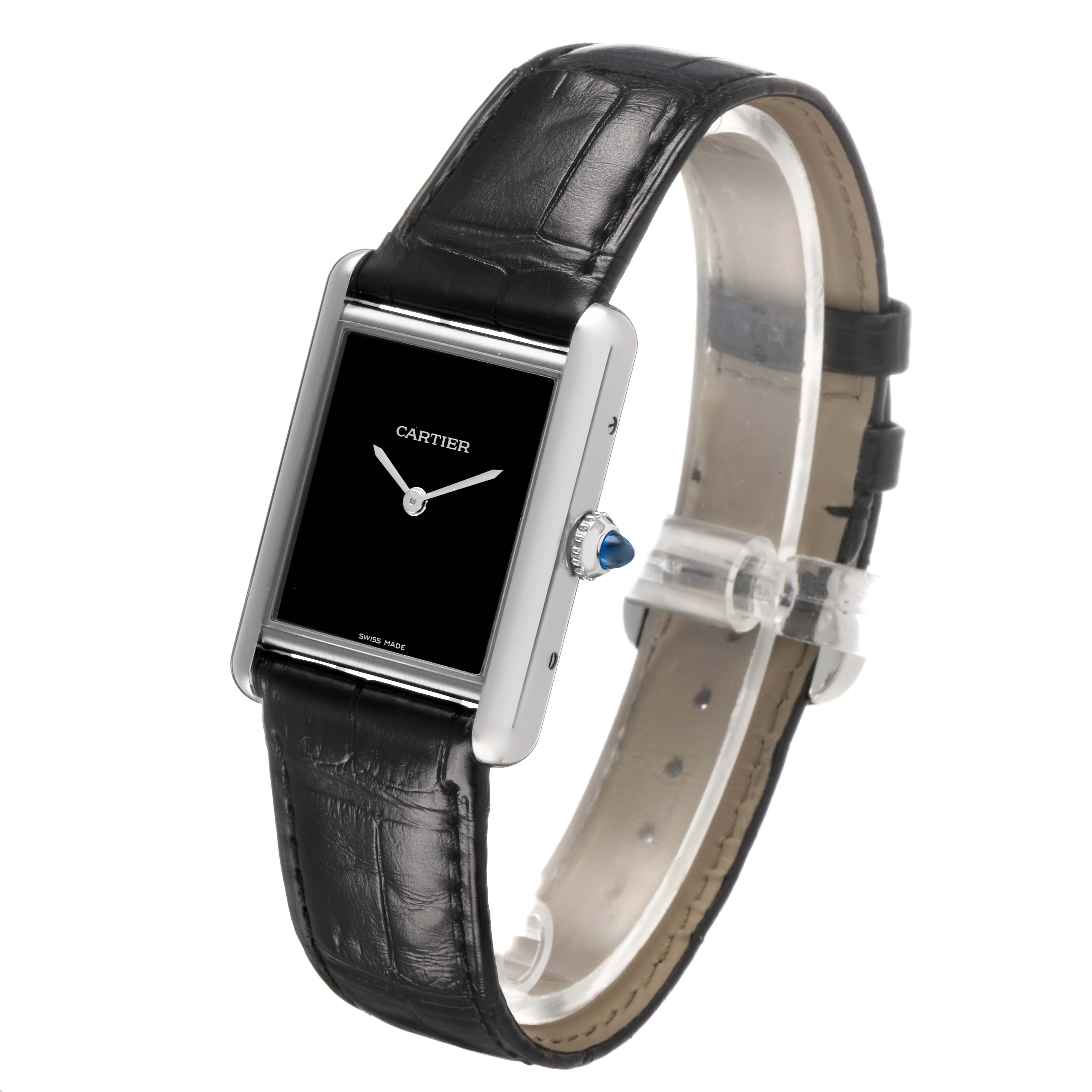 The Cartier Tank Must WSTA0072 Women's Stainless Steel Black Dial watch is shown at an angled view featuring its rectangular face, black leather strap, and blue cabochon crown.