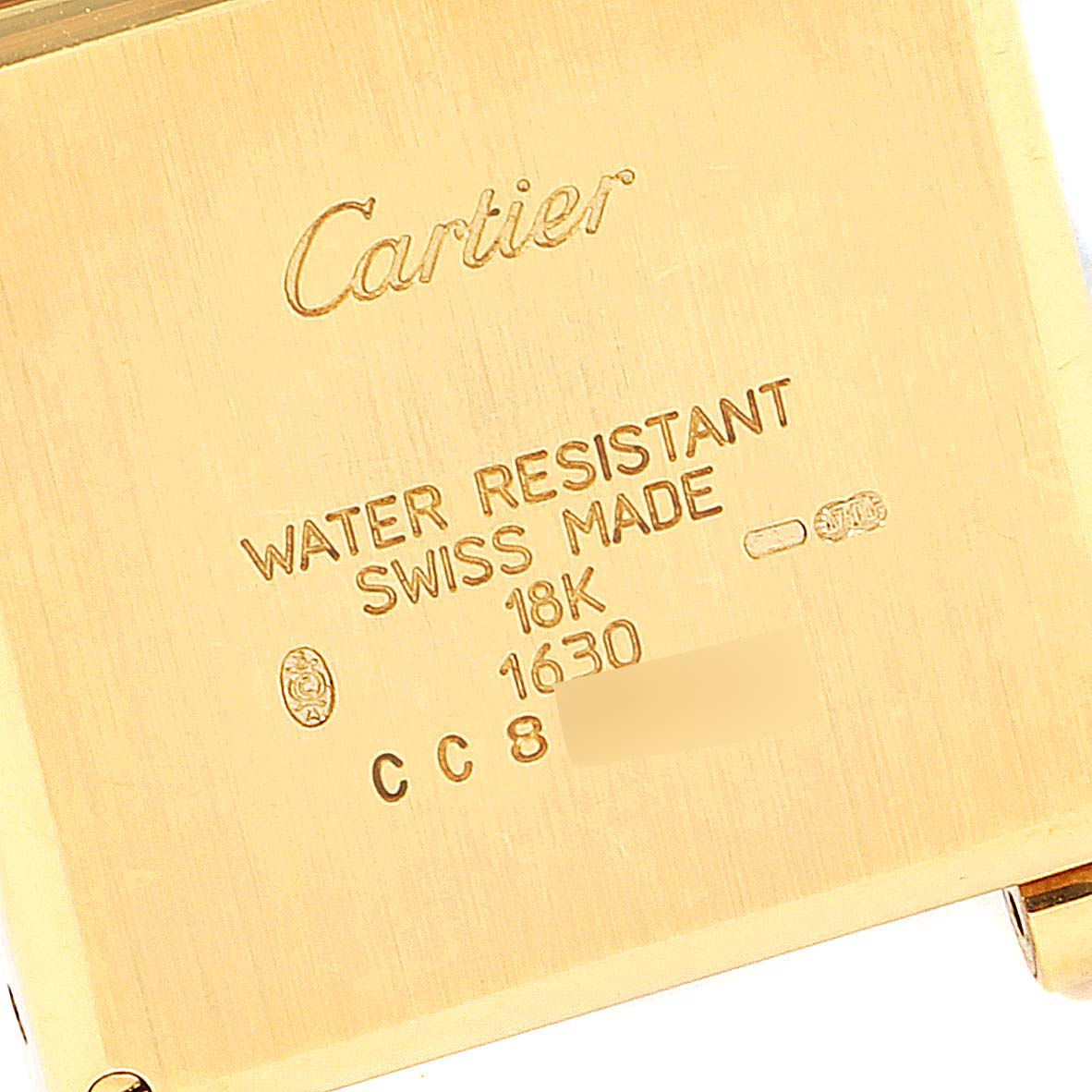 This image shows the back case of a Cartier Tank Obus 1630 Women's Yellow Gold Silver Dial 1630 Women's Yellow Gold Silver Dial watch, highlighting its engravings and hallmarks.