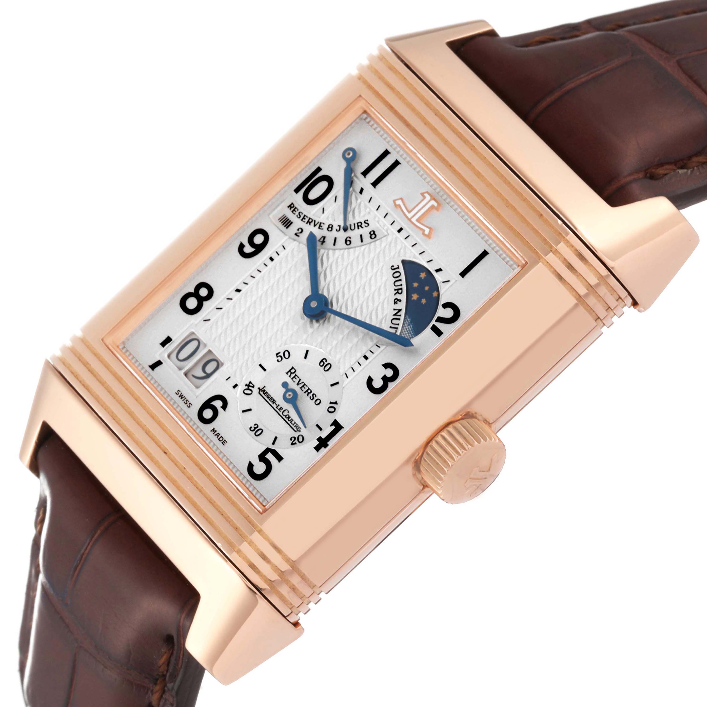 The Jaeger-LeCoultre Reverso watch is shown at an angle highlighting the dial, crown, and leather strap.