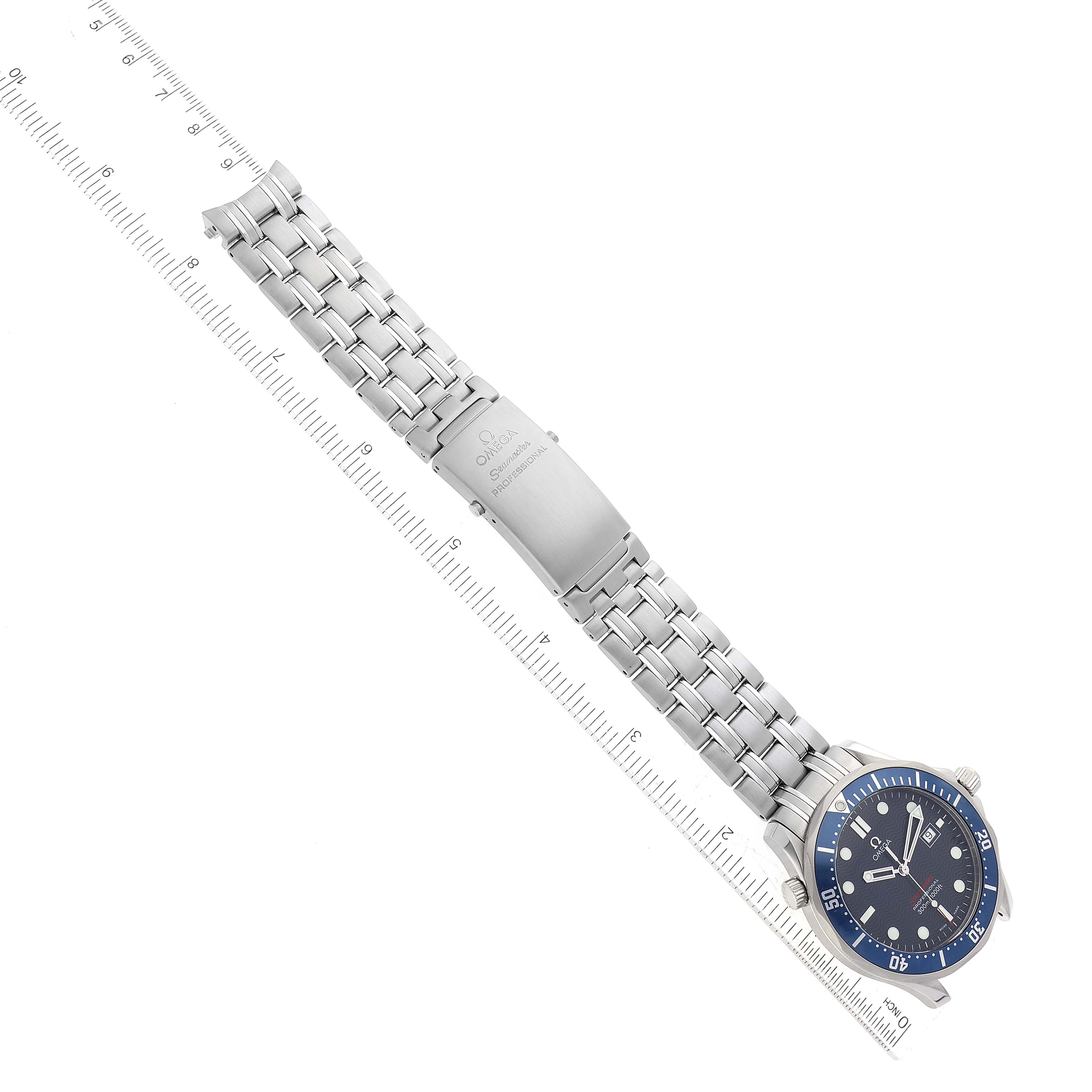 The Omega Seamaster 2221.80.00 Men
s Stainless Steel Blue Dial 2221.80.00 Men
s Stainless Steel Blue Dial watch is shown from an overhead angle, displaying its face, bezel, and metal bracelet alongside a ruler.