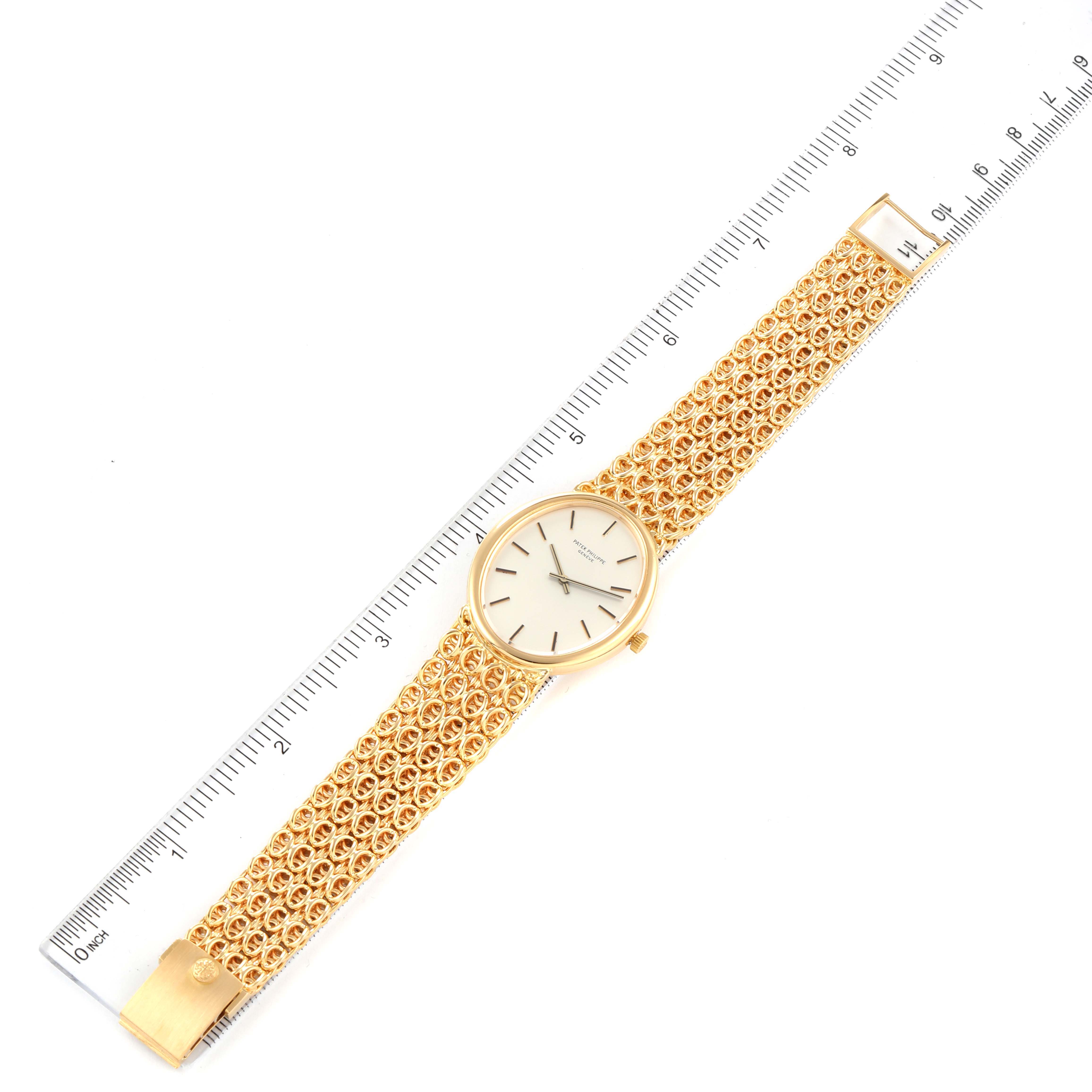 The image shows a Patek Philippe Golden Ellipse 3598 Men's Yellow Gold Silver Dial 3598 Men's Yellow Gold Silver Dial watch laid flat with a gold bracelet, alongside a ruler for scale.