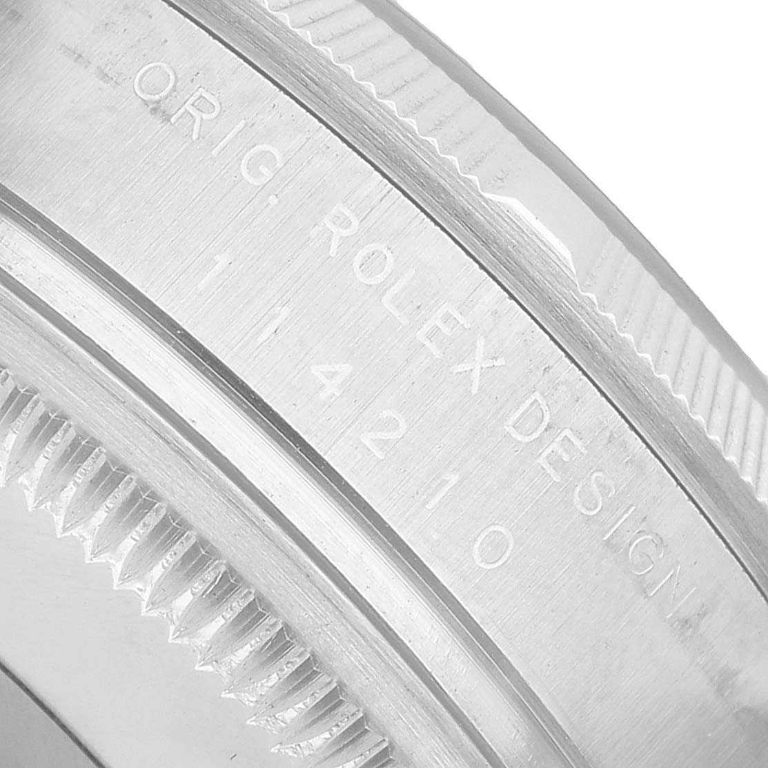 The image shows a close-up side angle of the inner bezel with engraved text on a Rolex Air-King 114210 Men's Stainless Steel Silver Dial watch.