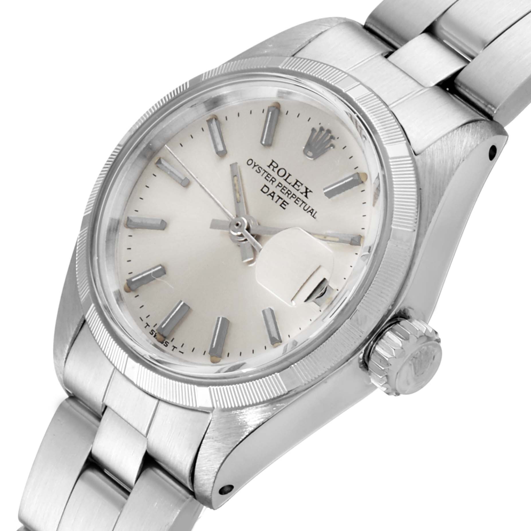 The image shows a Rolex Date 6919 Women
s Stainless Steel Silver Dial 6919 Women
s Stainless Steel Silver Dial Oyster Perpetual watch at an angled view, displaying the dial, bezel, crown, and part of the bracelet.