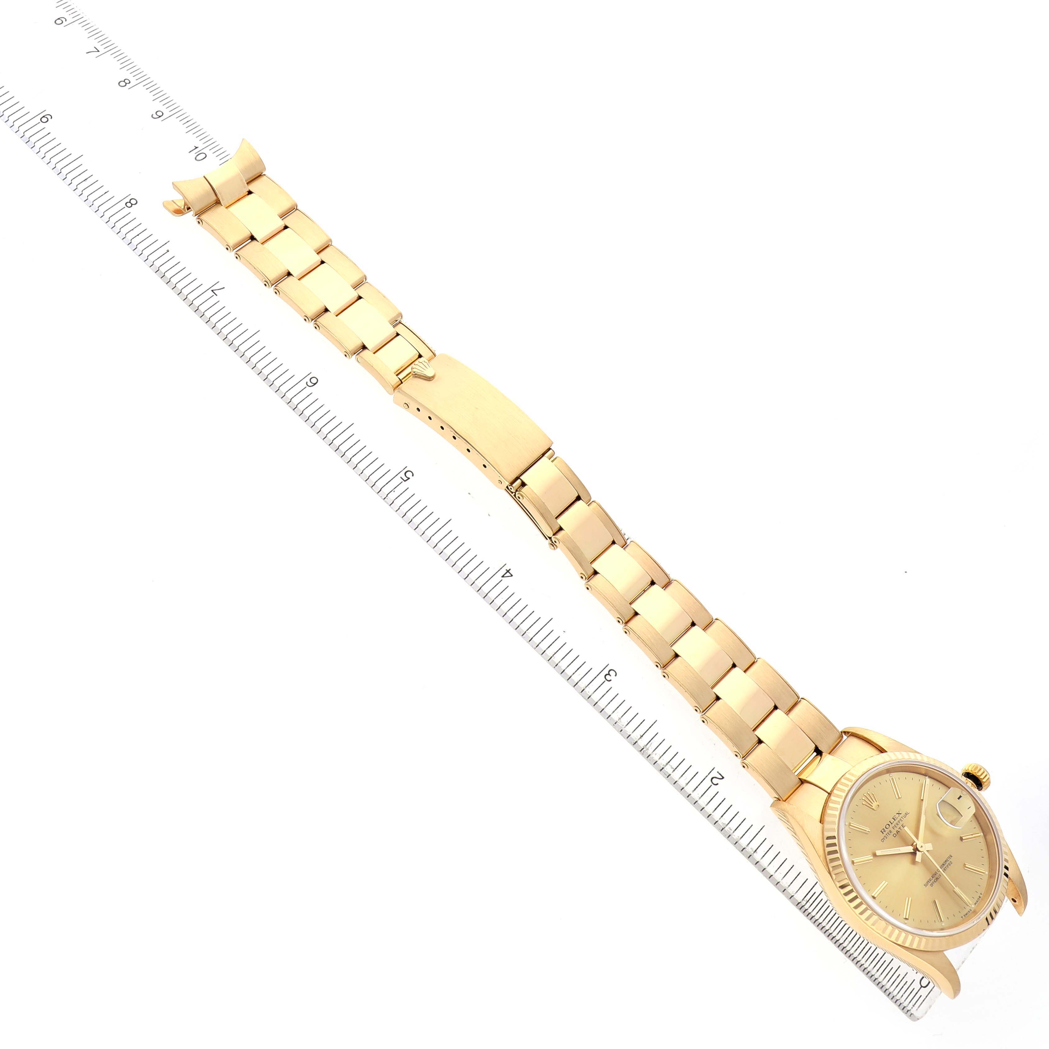 The Rolex Date 15238 Men's Yellow Gold Champagne Dial watch is shown from an angled overhead view, featuring the dial, bracelet, and clasp alongside a ruler.