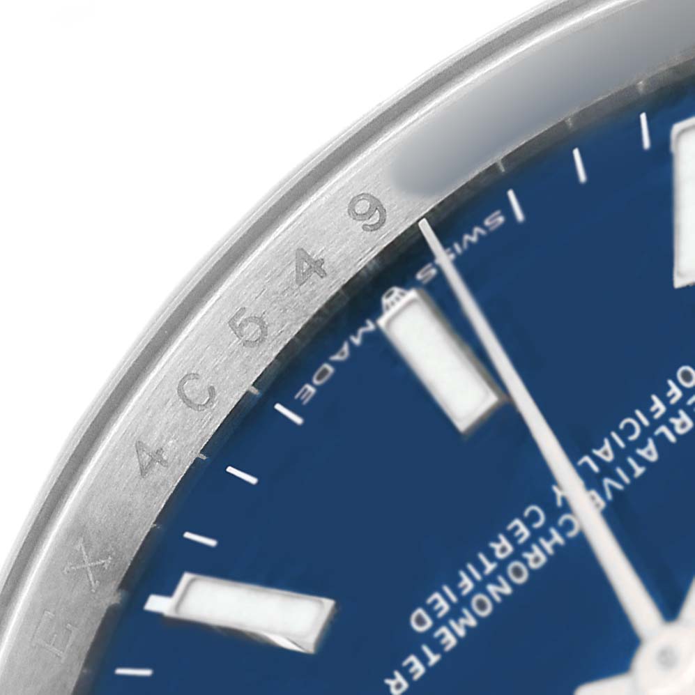 The image shows a partial close-up of the dial and bezel, highlighting the markers and inscriptions on this Rolex Datejust 126200 Men's Stainless Steel Blue Dial watch.