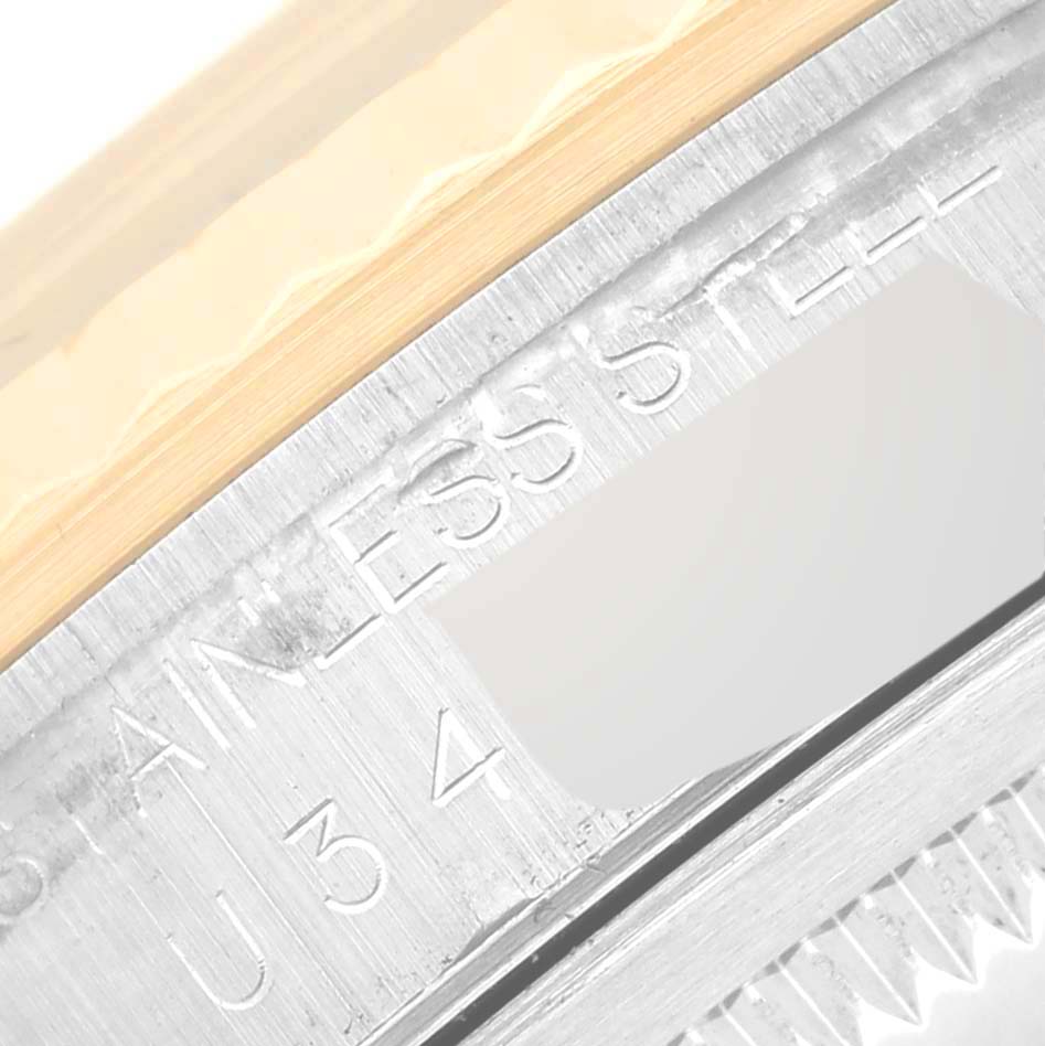This image shows a close-up of the case and bezel of a Rolex Datejust 16233 Men's Steel and Gold (two tone) Black Dial 16233 Men's Steel and Gold (two tone) Black Dial watch, highlighting the engraved serial number and stainless steel text.