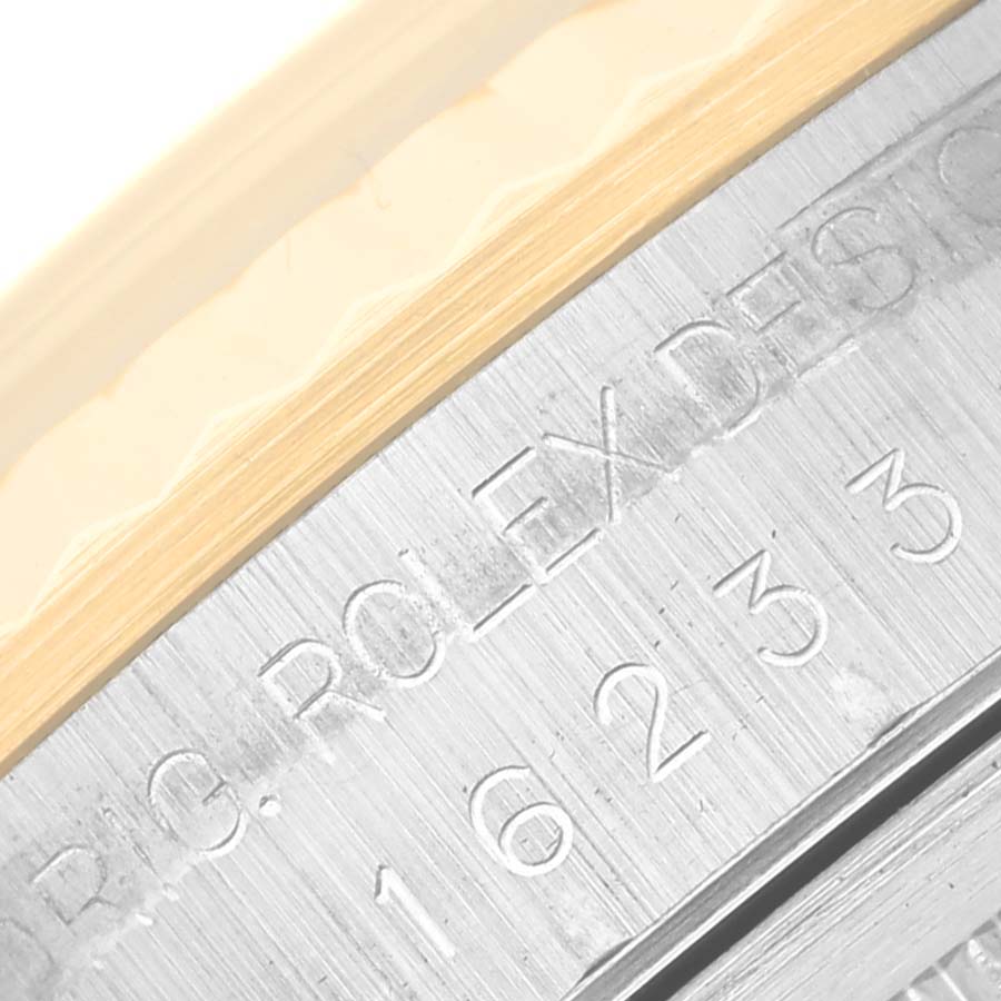 This close-up angle shows the engraved text and model number on the case of a Rolex Datejust 16233 Men's Steel and Gold (two tone) Black Dial 16233 Men's Steel and Gold (two tone) Black Dial watch.
