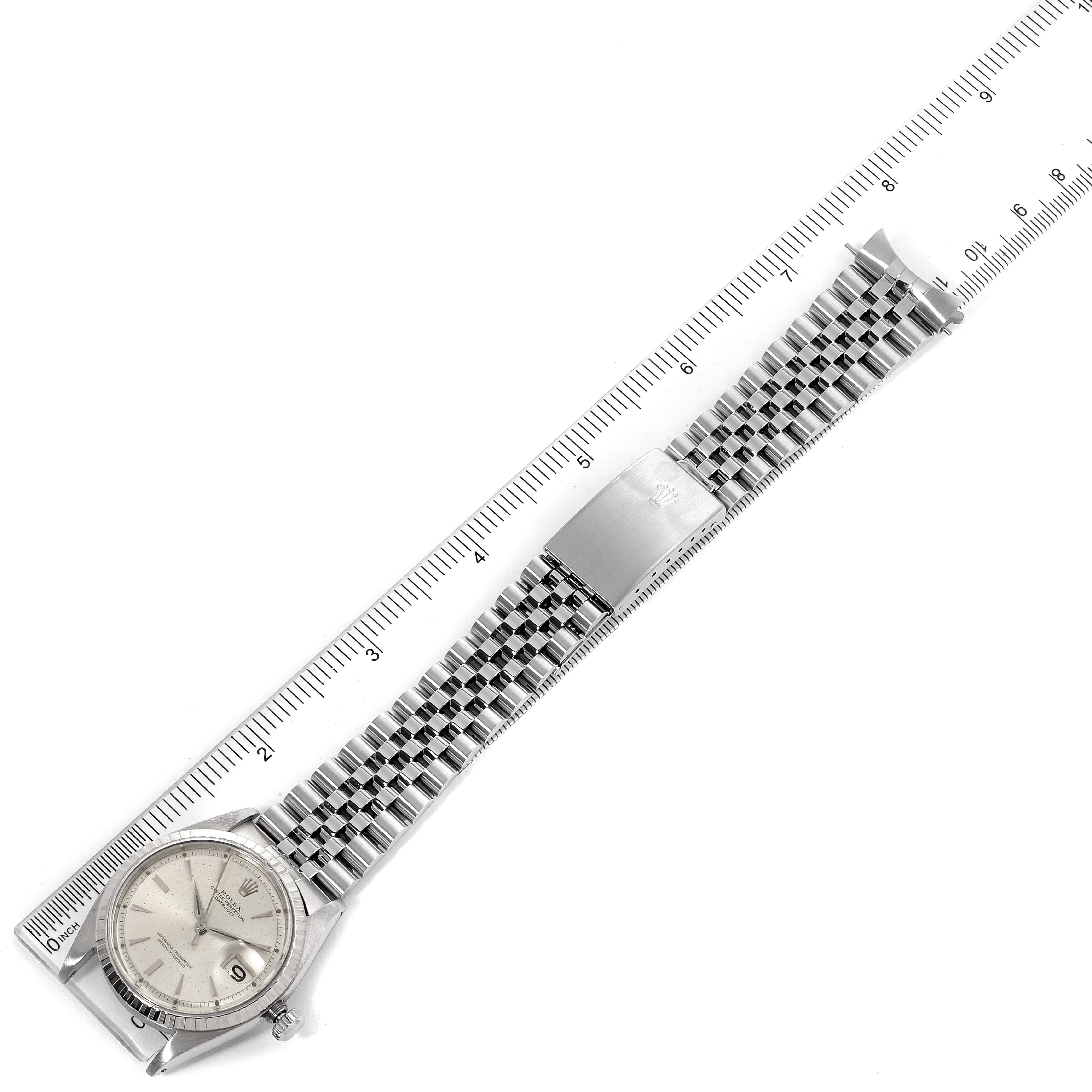 This image shows a top view of a Rolex Vintage Collection 1603 Men
s Stainless Steel Silver Dial 1603 Men
s Stainless Steel Silver Dial watch, displaying its dial, bracelet, and clasp alongside a ruler for scale.