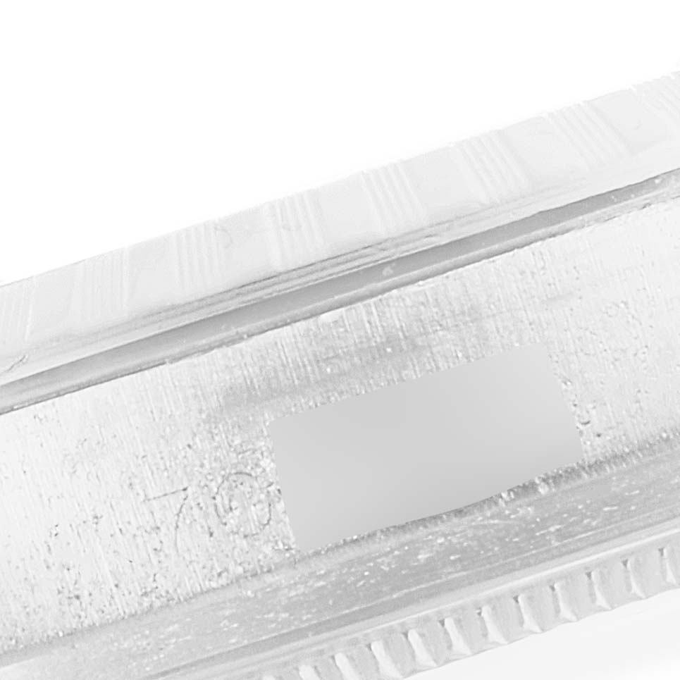 This close-up image shows the side bezel and part of the engraved case back of a Vintage Collection model by Rolex.