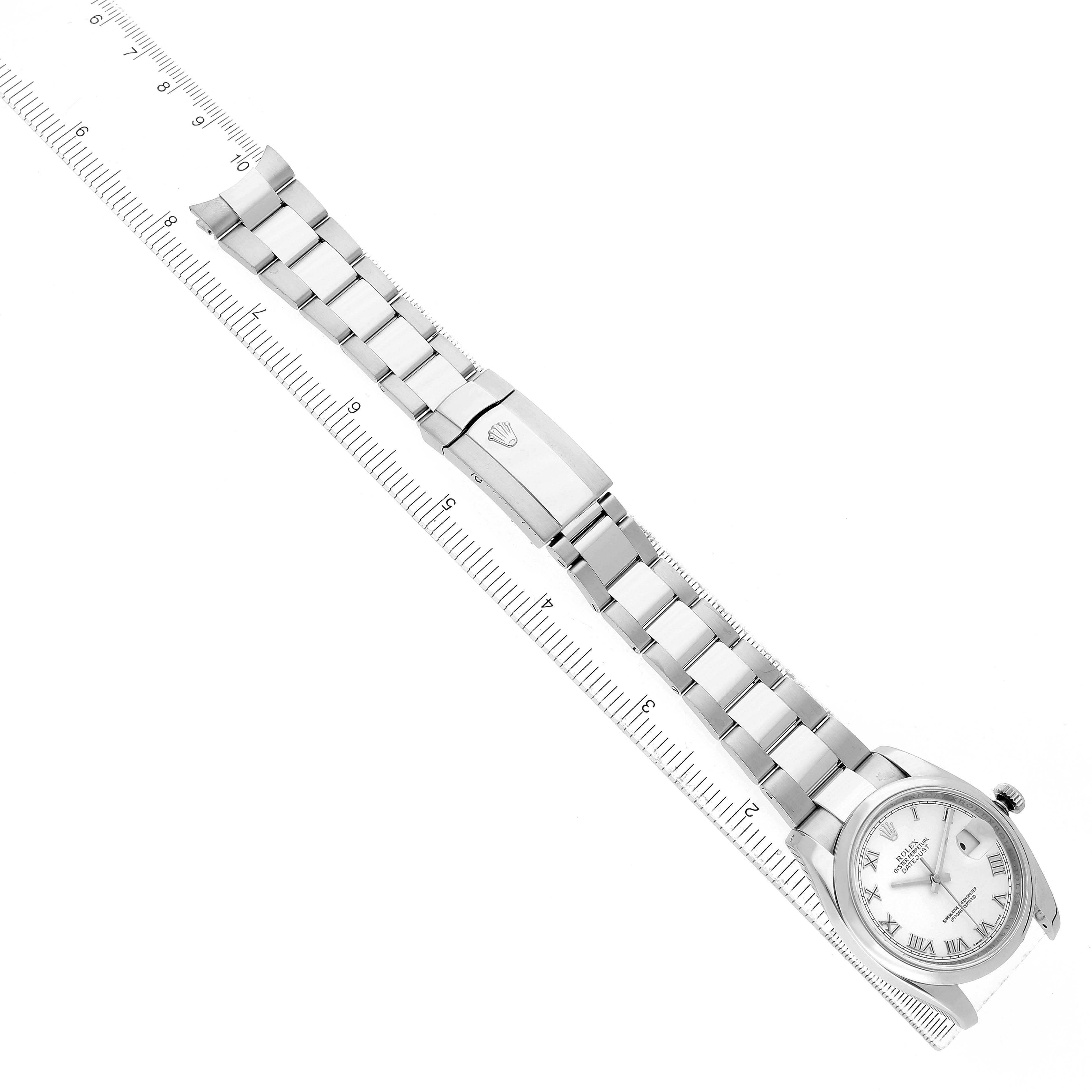 The image shows a Rolex Datejust 116200 Men's Stainless Steel White Dial watch laid flat with the bracelet and clasp, next to a ruler for scale.
