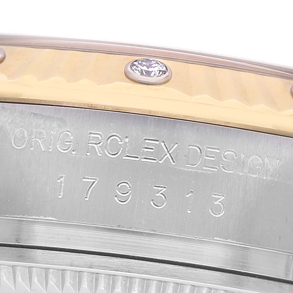The image shows a close-up of the Rolex Datejust 179313 Men's Steel and Gold (two tone) Silver Dial's engraved side, highlighting design details and a diamond embellishment.
