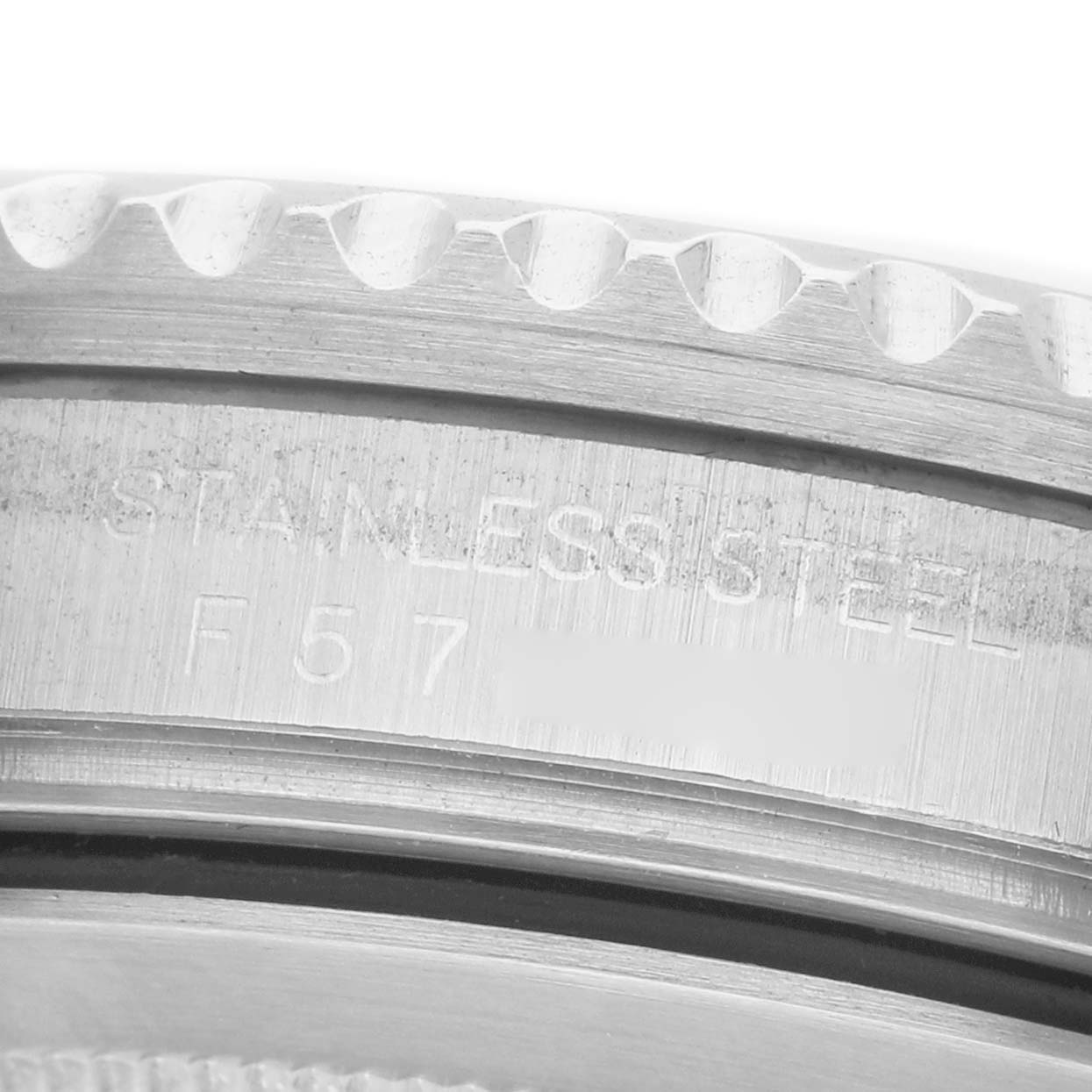 The image shows a close-up of the side of a Rolex GMT-Master 16710 Men's Stainless Steel Black Dial watch case with visible "STAINLESS STEEL" engraving.