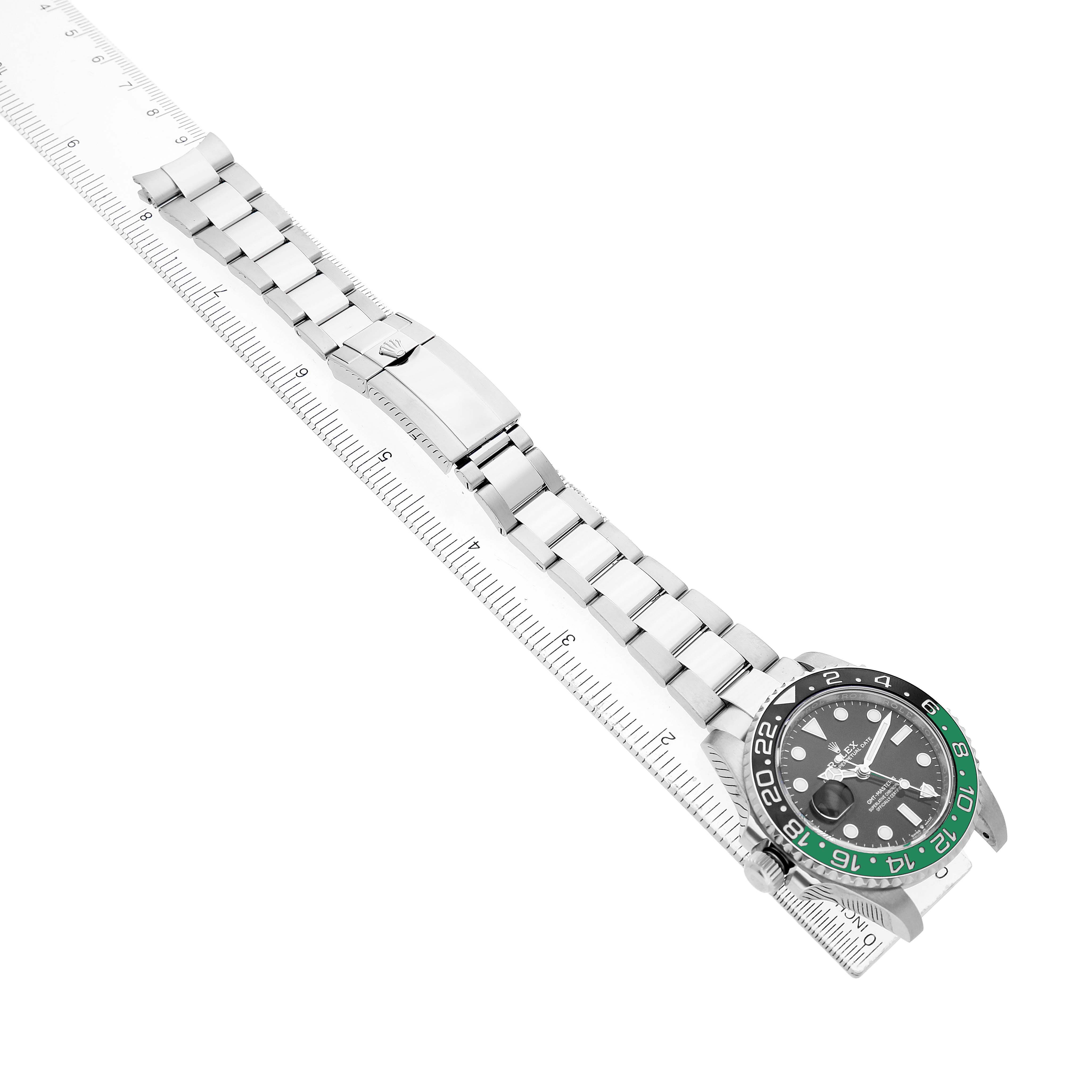 The Rolex GMT-Master 126720VTNR Men's Stainless Steel Black Dial watch is shown diagonally, displaying the face, bezel, and entire bracelet along a ruler.