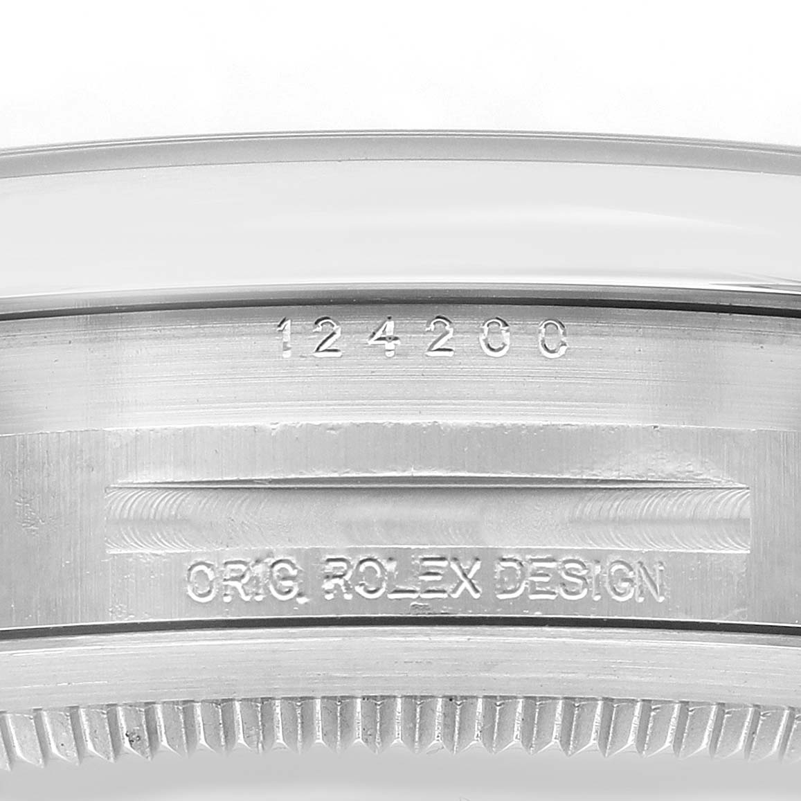 The image shows a close-up of the engraved bezel edge and case side of a Rolex Oyster Perpetual 124200 Men's Stainless Steel Pink Dial watch.