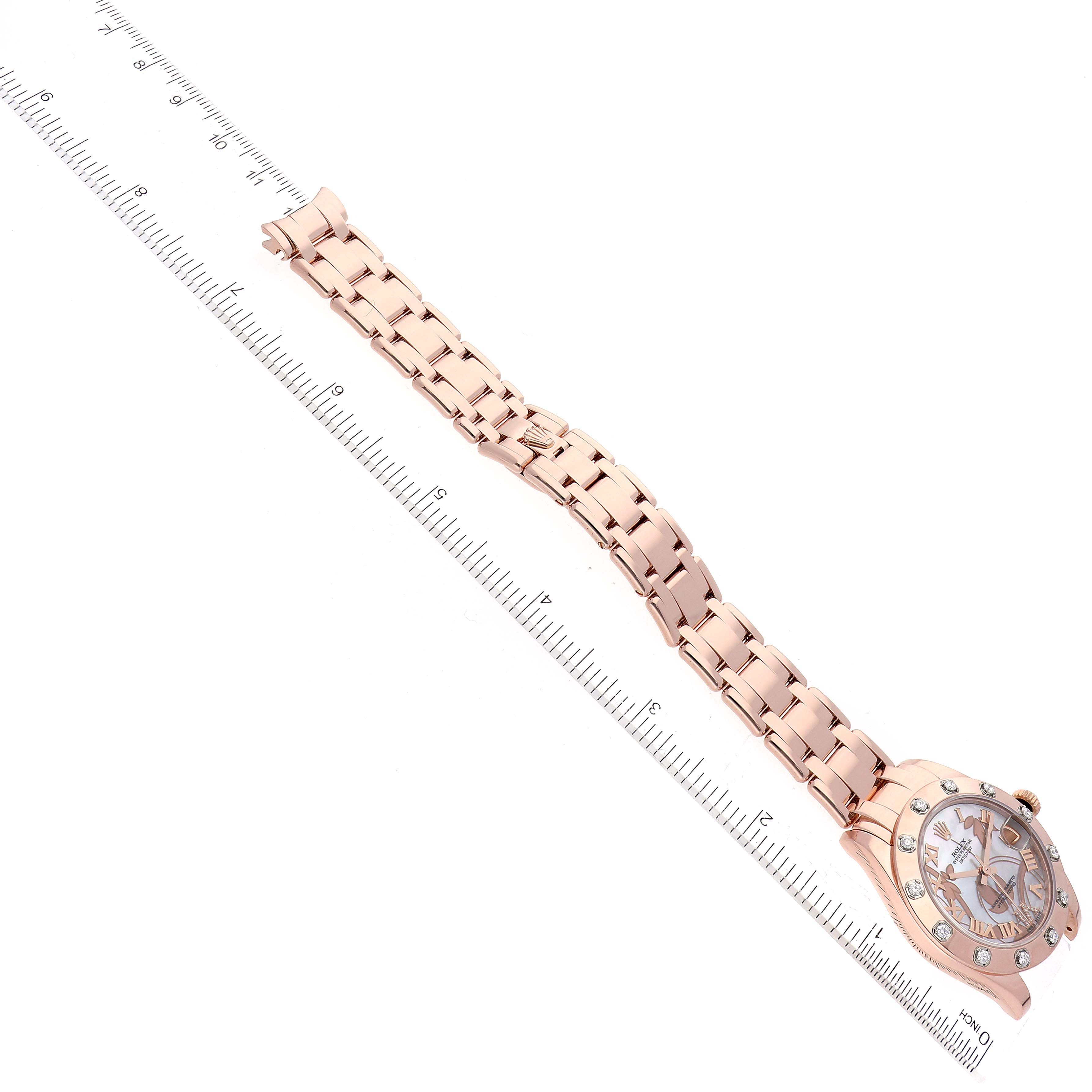 The Rolex Pearlmaster 81315 Women
s Rose Gold Mother of Pearl Dial 81315 Women
s Rose Gold Mother of Pearl Dial watch is shown at an angled view, highlighting the face, bezel, and full bracelet against a measuring ruler.