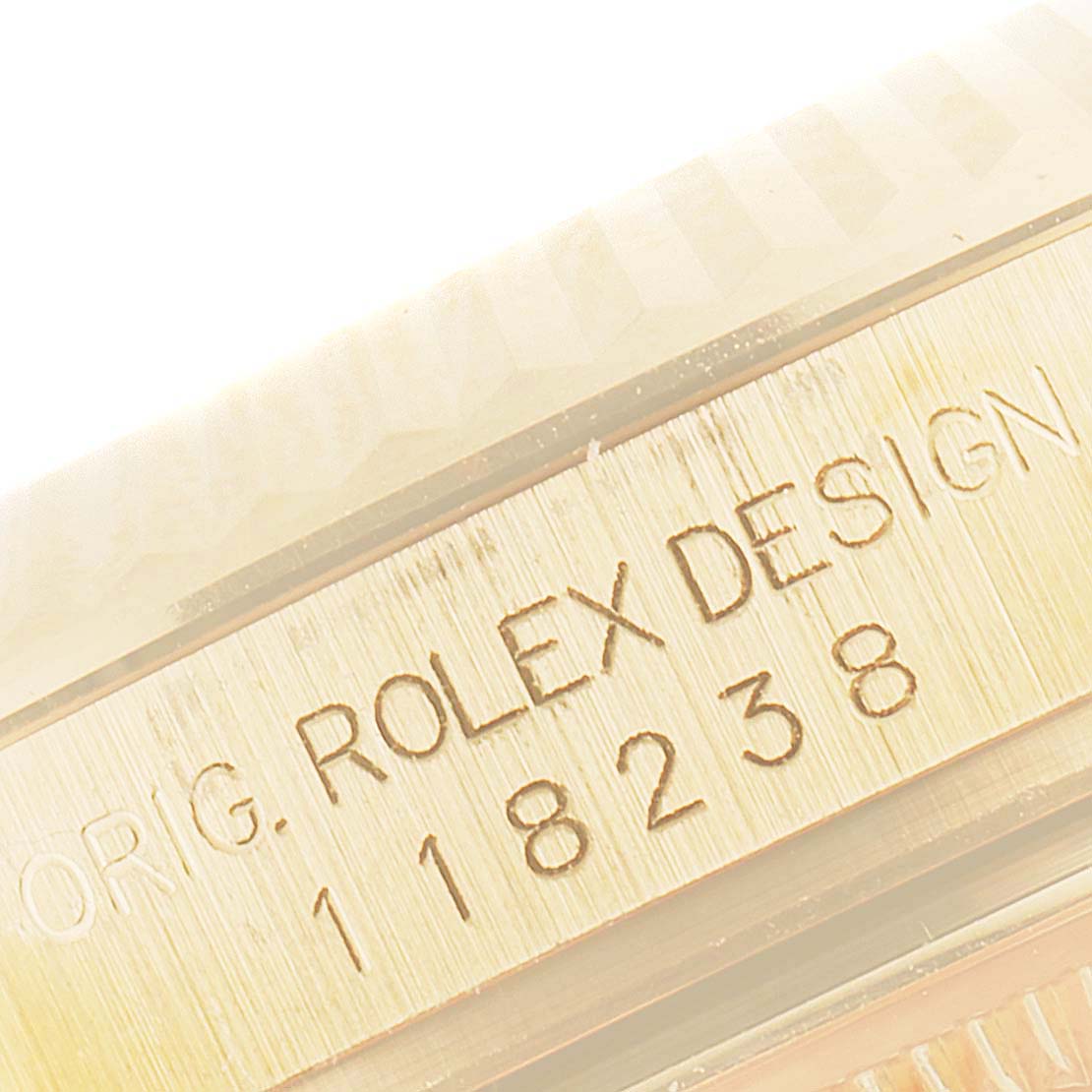 The image shows a close-up of the side of the Rolex President 118238 Men
s Yellow Gold Black Dial 118238 Men
s Yellow Gold Black Dial model, highlighting the bezel and engraved model number.