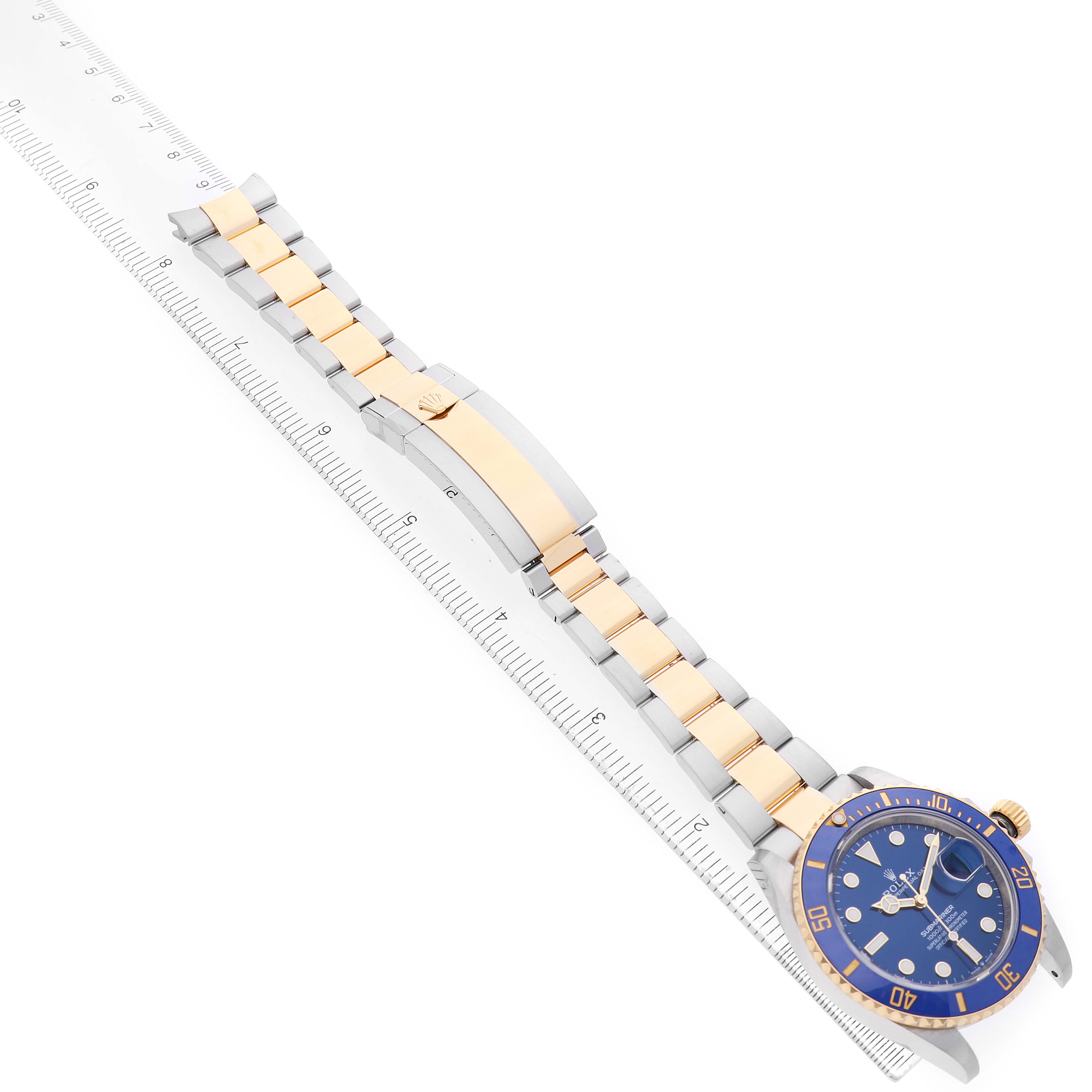 The image shows the Rolex Submariner 126613 Men's Steel and Gold (two tone) Blue Dial watch laid flat, displaying the bracelet, clasp, and the watch face with a blue dial and bezel.
