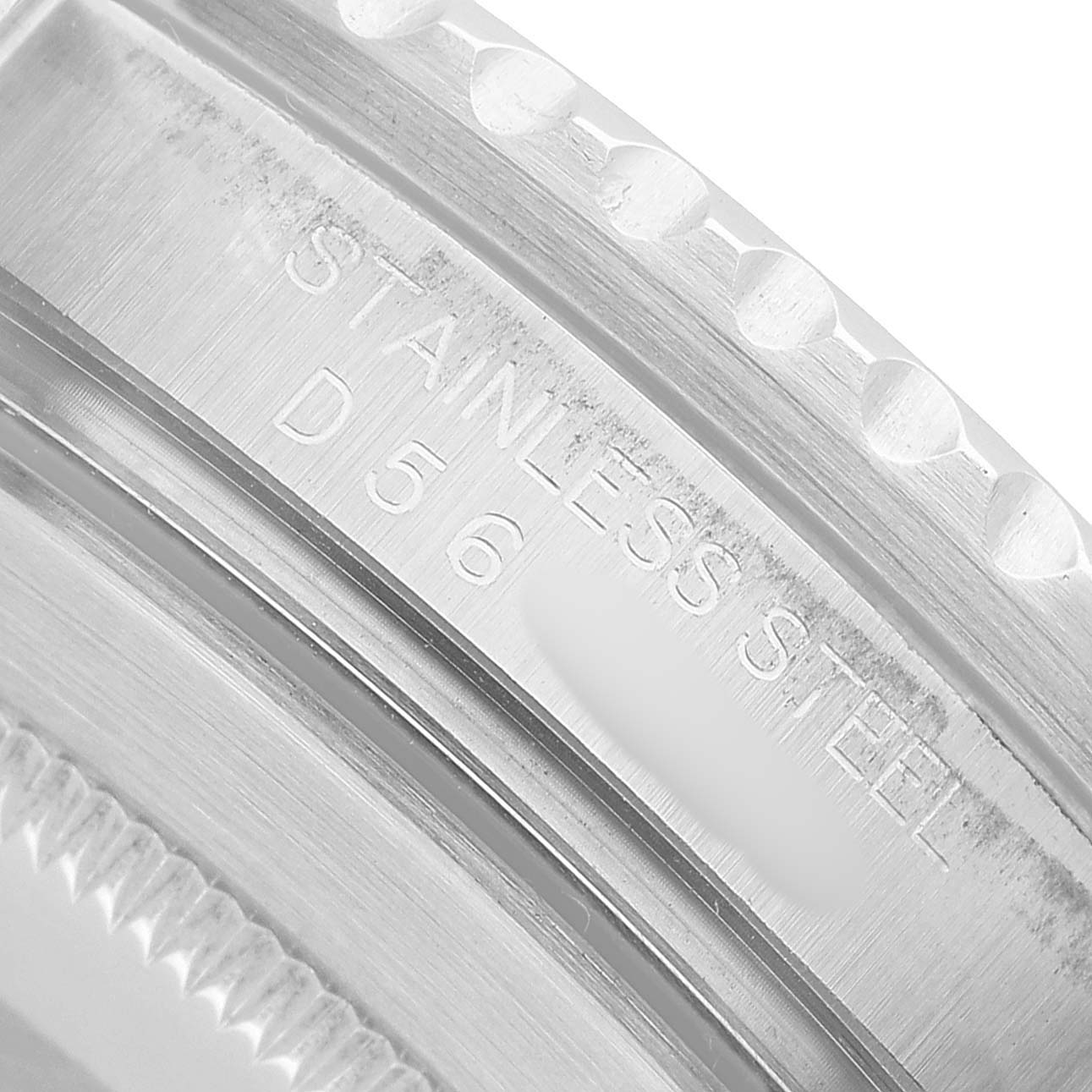 The image shows a close-up of the Rolex Submariner 16610 Men's Stainless Steel Black Dial's stainless steel case with engraved text.