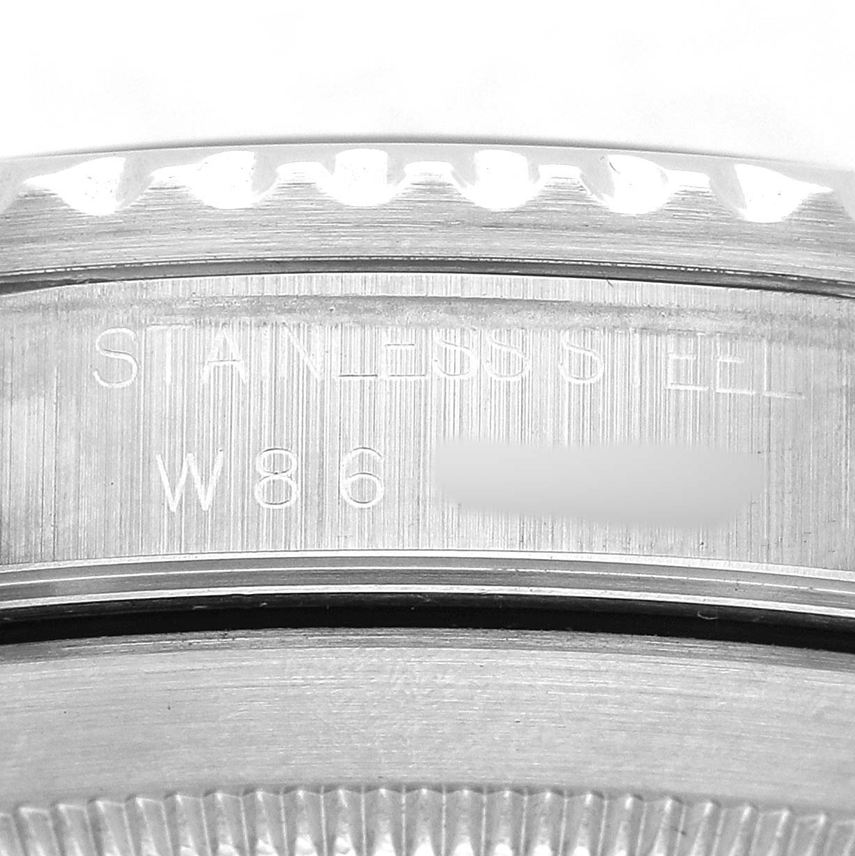 The image shows the side profile of the Rolex Submariner 14060 Men's Stainless Steel Black Dial's bezel and part of its engraved case back.