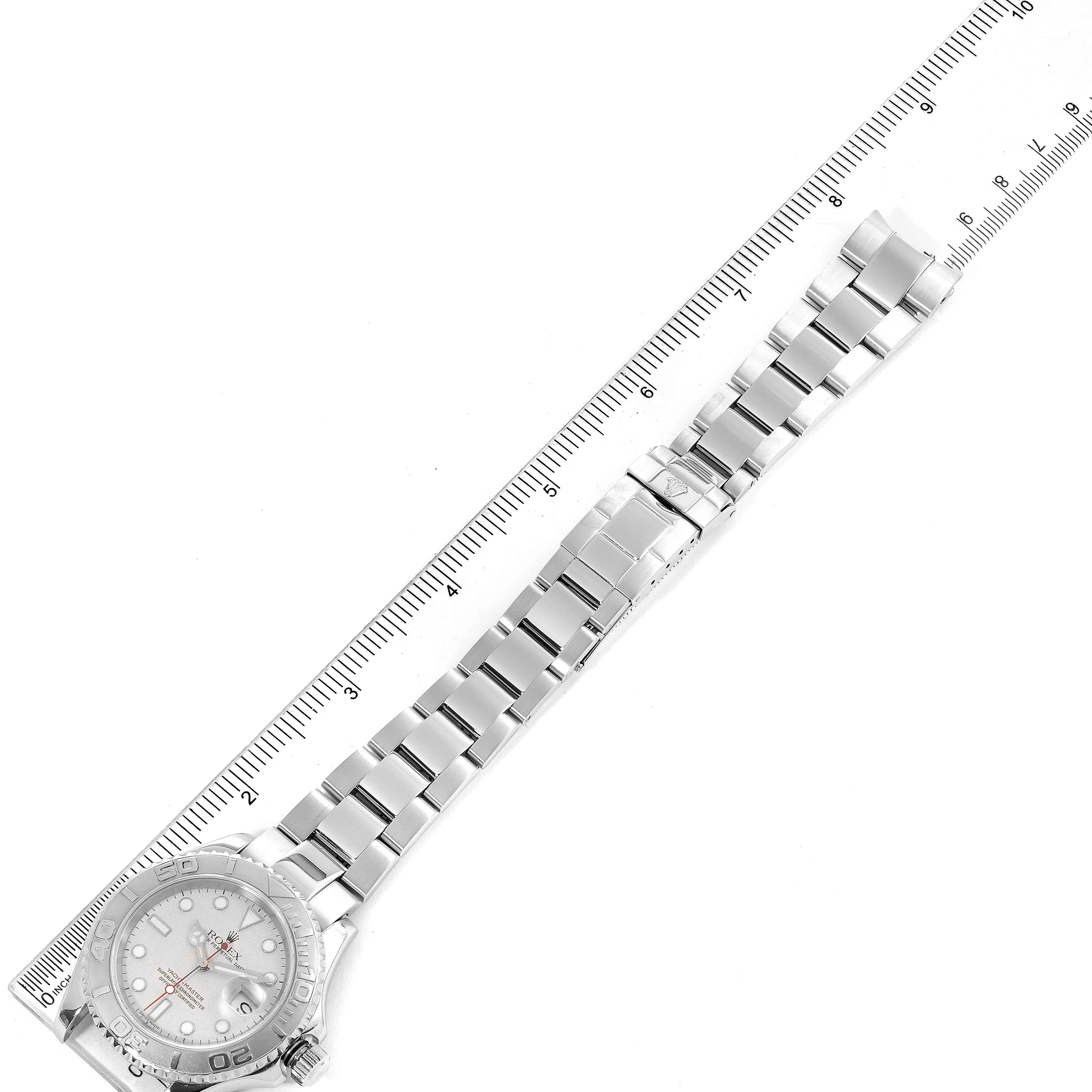 This image shows the Rolex Yacht-Master 16622 Men
s Stainless Steel Silver Dial 16622 Men
s Stainless Steel Silver Dial watch laid flat, displaying the watch face, bracelet, and a measuring scale beside it.