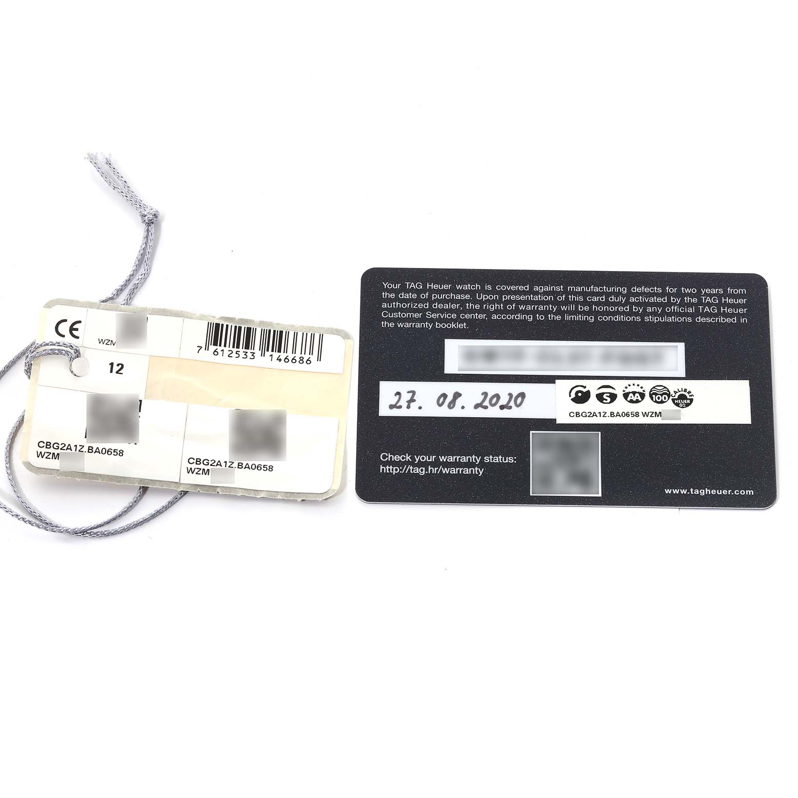 The image shows the warranty card and tags for a Tag Heuer Carrera CBG2A1Z.BA0658 Men's Stainless Steel Black Dial CBG2A1Z.BA0658 Men's Stainless Steel Black Dial model watch, photographed from above.