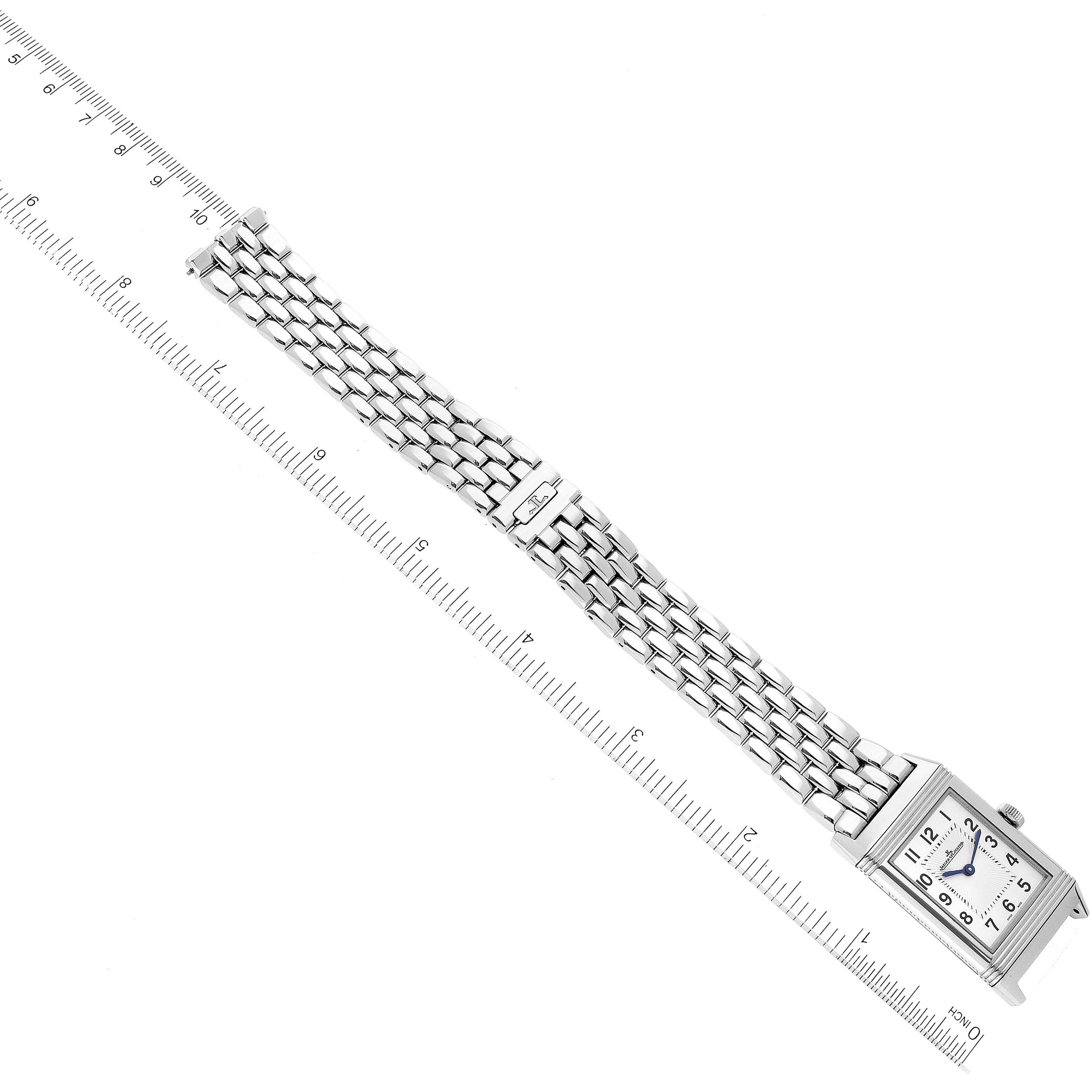 This image shows a Jaeger LeCoultre Reverso Q2548120 Men's Stainless Steel Silver Dial Q2548120 Men's Stainless Steel Silver Dial watch with a rectangular face and a metal link bracelet, placed next to a ruler for scale.