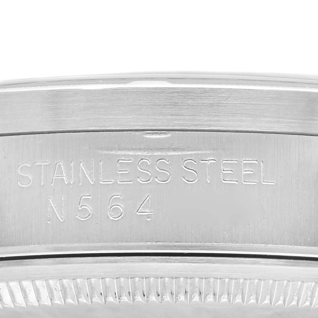 The image shows a close-up of the stainless steel bezel and side of a Rolex Air-King 14010 Men's Stainless Steel Blue Dial 14010 Men's Stainless Steel Blue Dial watch case with engraved text.