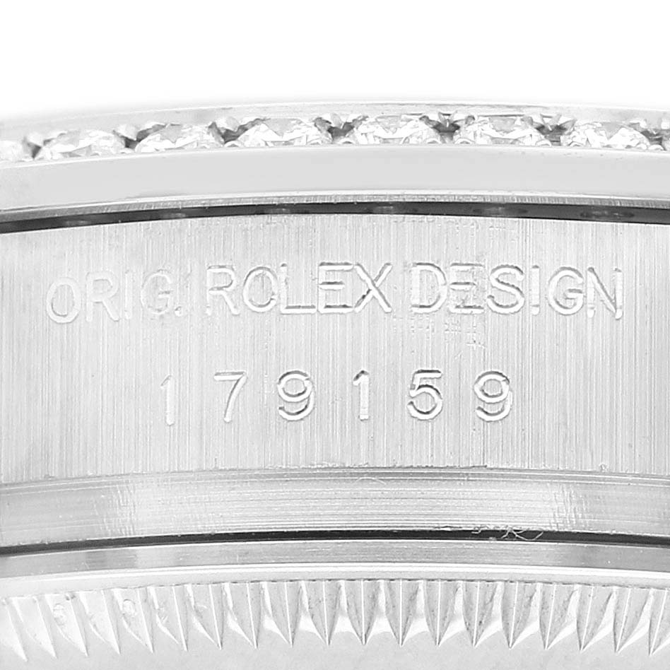 The image shows a close-up of a Rolex President 179159 Women's White Gold Silver Dial watch bezel with engraved text, displaying part of the outer edge.