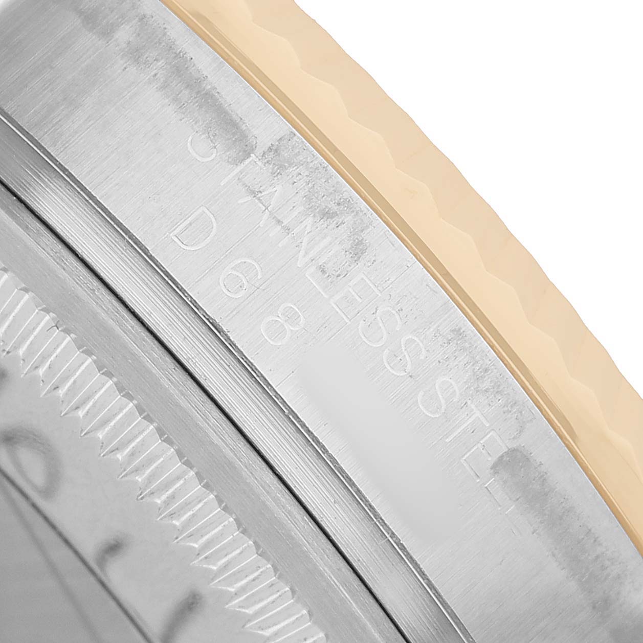 The image shows a close-up of the Rolex Datejust 116233 Men's Steel and Gold (two tone) Grey Dial's bezel and edge, featuring branding and material details.