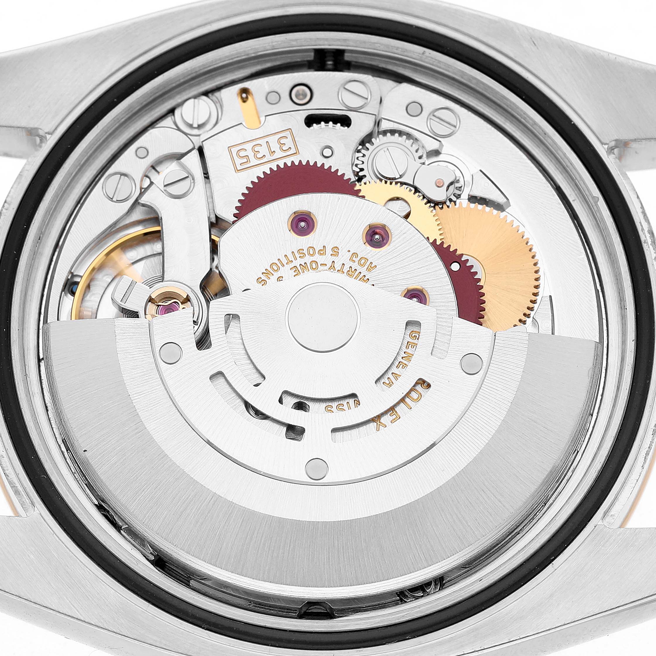 The image shows the movement of a Rolex Datejust 116233 Men's Steel and Gold (two tone) Grey Dial watch, viewed from the back with gears and components visible.