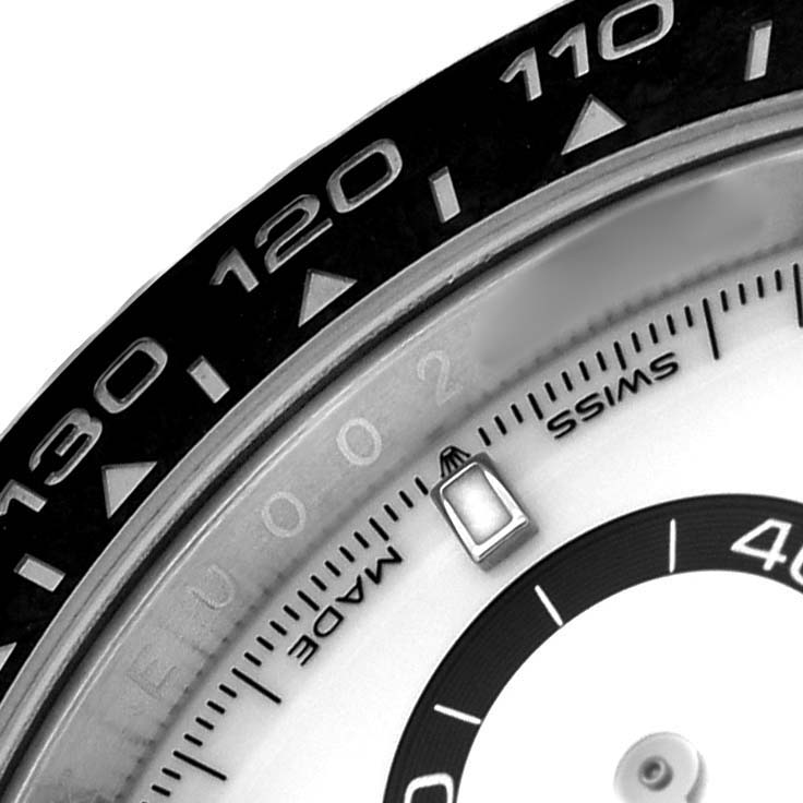 The image shows a close-up of a Rolex Daytona 126500 Men's Stainless Steel White Dial watch, highlighting the bezel with tachymeter markings and part of the dial.