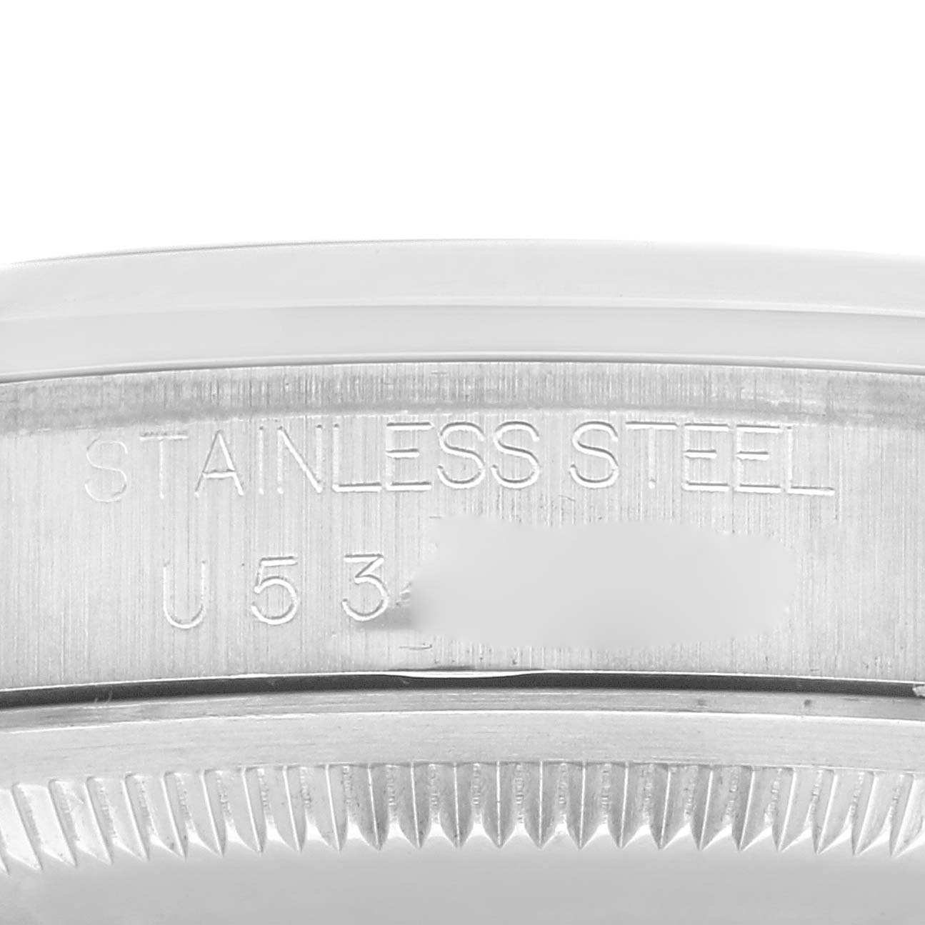 The image shows a close-up of the case back edge of a Rolex Explorer 14270 Men
s Stainless Steel Black Dial 14270 Men
s Stainless Steel Black Dial watch, displaying the "STAINLESS STEEL" engraving.